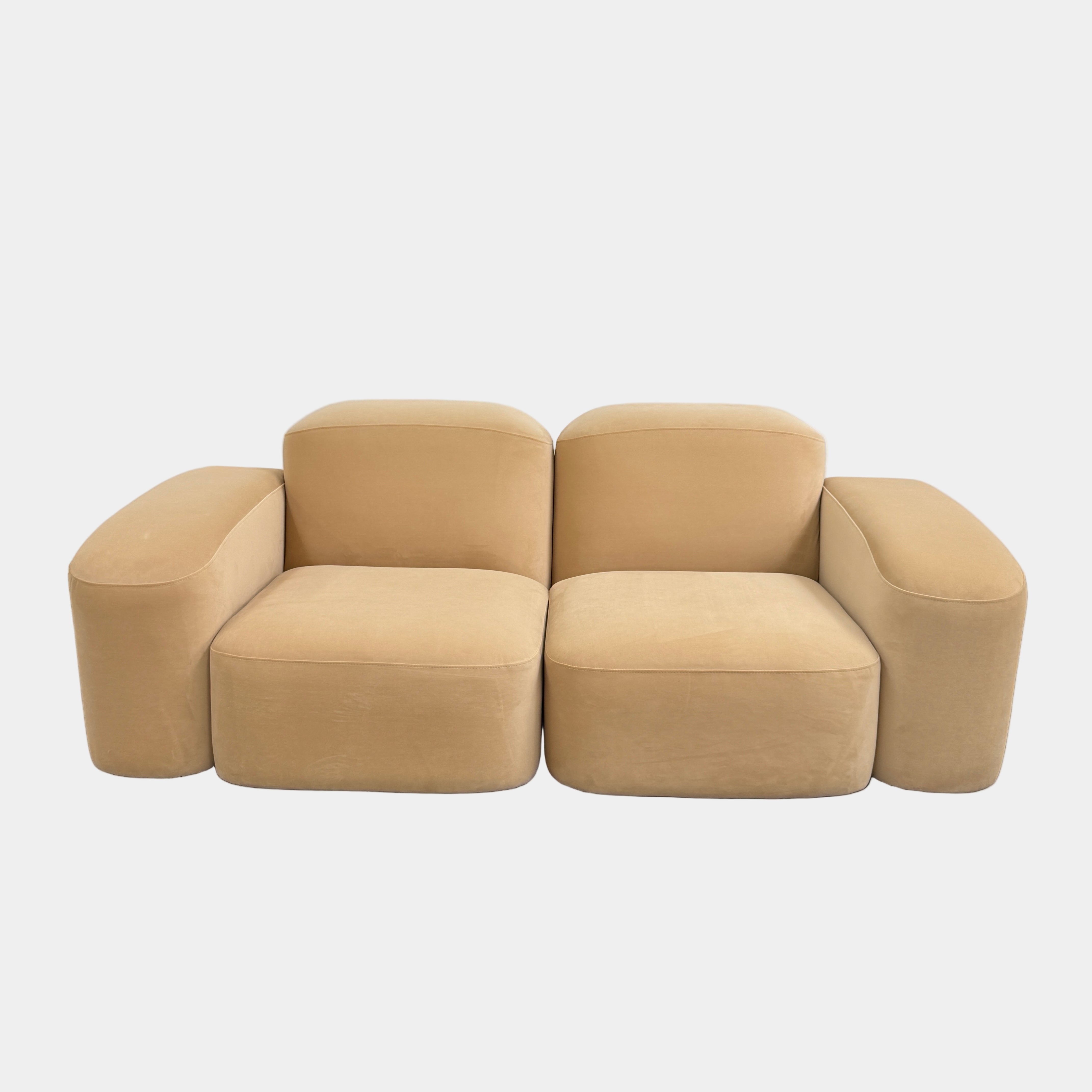 Beige  sofa on a gray floor with a white wall background