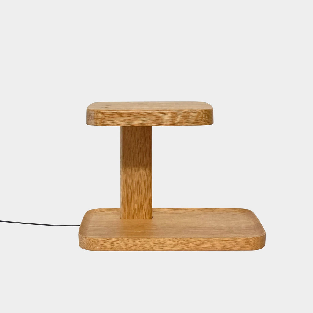 The Flos Piani Table Light by Flos is a sleek wooden lamp with a cord for easy use.