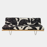 The Limited Edition Modernica + Cleon Peterson Case Study Daybed 2016 features metal hairpin legs and black-and-white cushions with abstract human figure illustrations by Cleon Peterson.