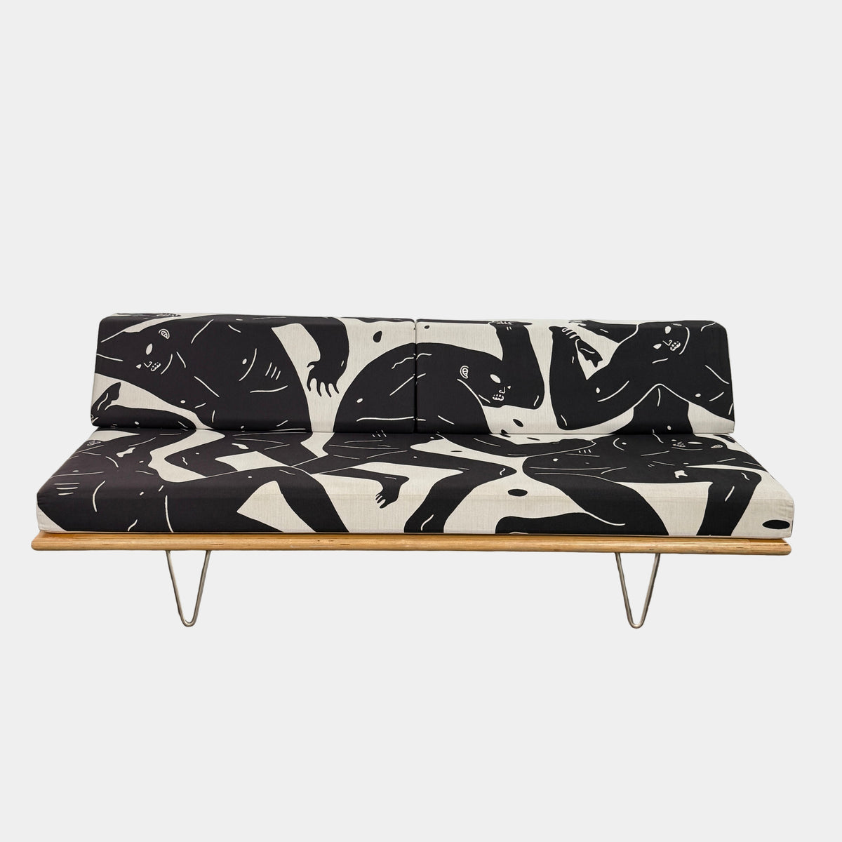 The Limited Edition Modernica + Cleon Peterson Case Study Daybed 2016 features metal hairpin legs and black-and-white cushions with abstract human figure illustrations by Cleon Peterson.