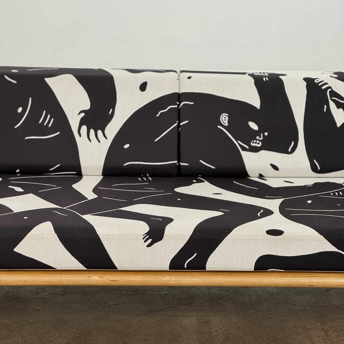 The Limited Edition Modernica + Cleon Peterson Case Study Daybed 2016 features metal hairpin legs and black-and-white cushions with abstract human figure illustrations by Cleon Peterson.