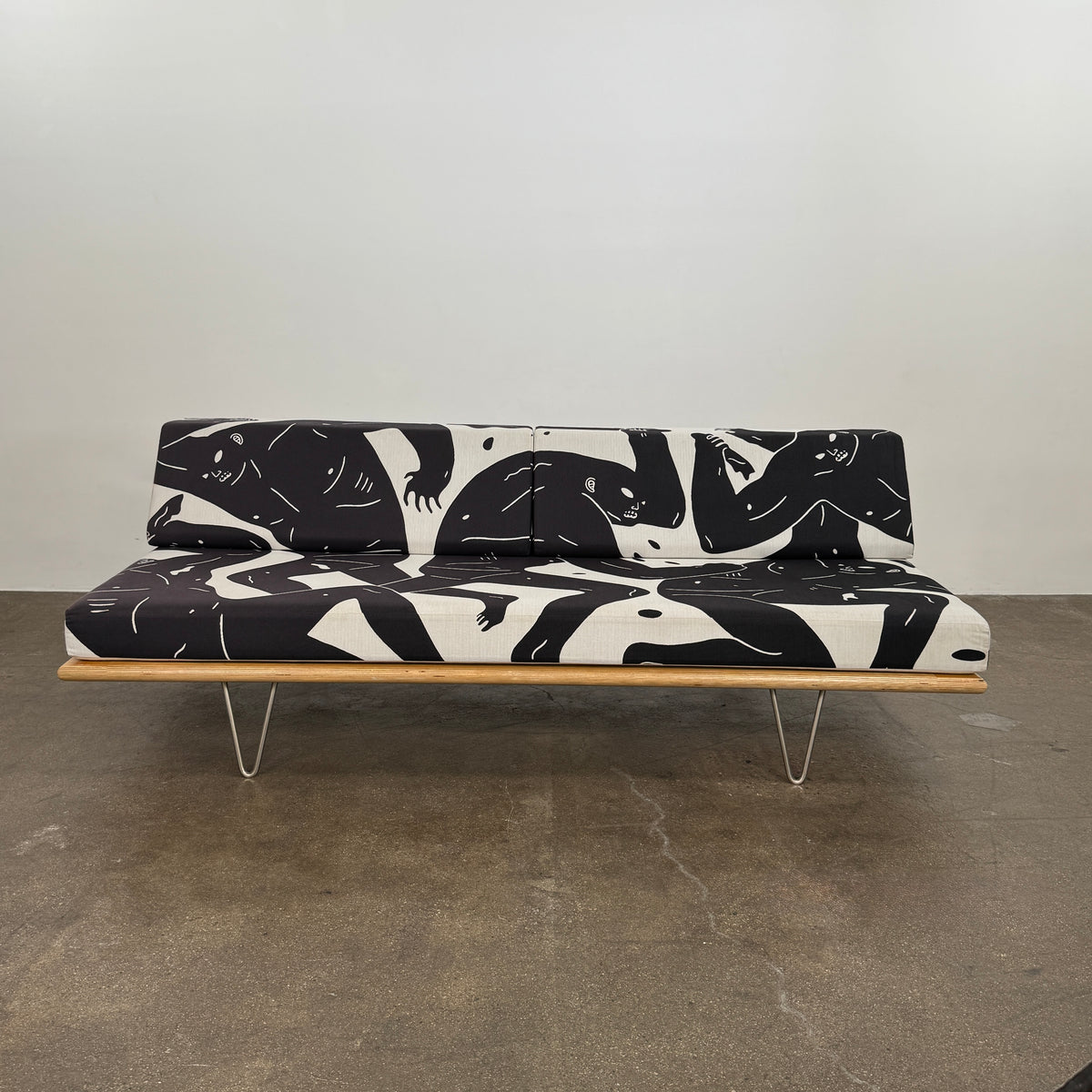 The Limited Edition Modernica + Cleon Peterson Case Study Daybed 2016 features metal hairpin legs and black-and-white cushions with abstract human figure illustrations by Cleon Peterson.