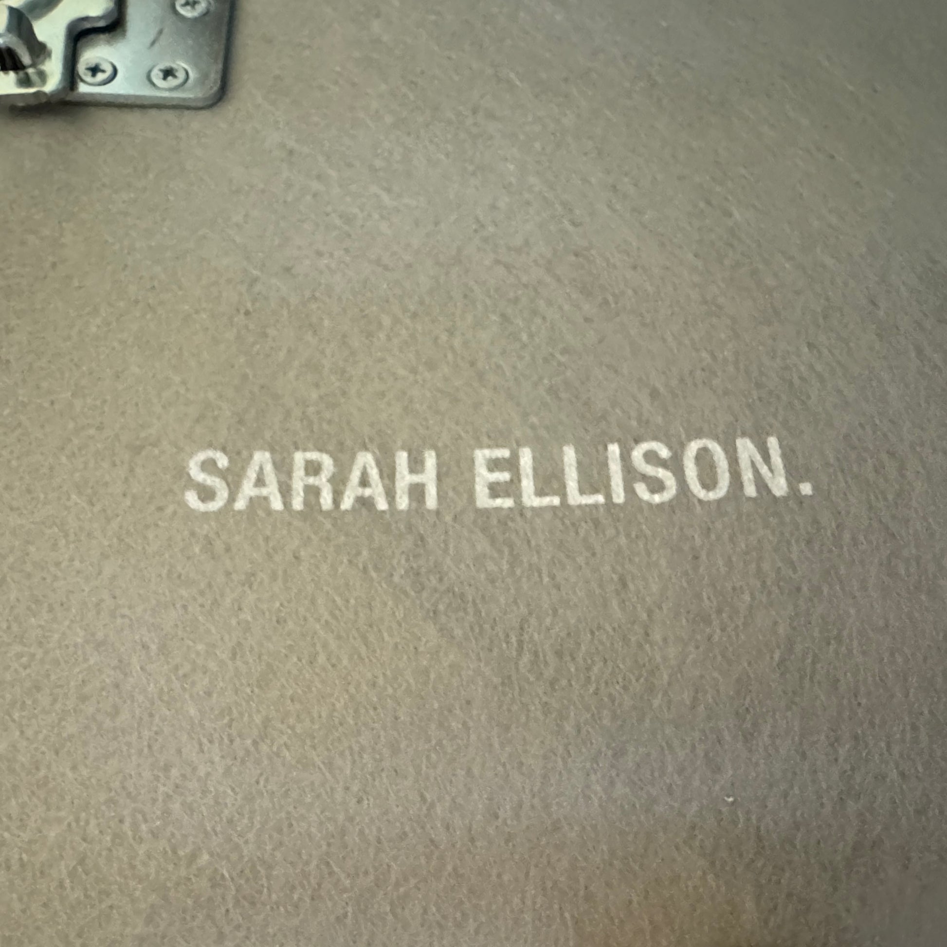 The Ellison Studios “Muse” Sofa Two Seater, in modern beige with plush rounded cushions and arms, channels Sarah Ellison’s signature style, shown here on a polished concrete floor against a plain light wall.