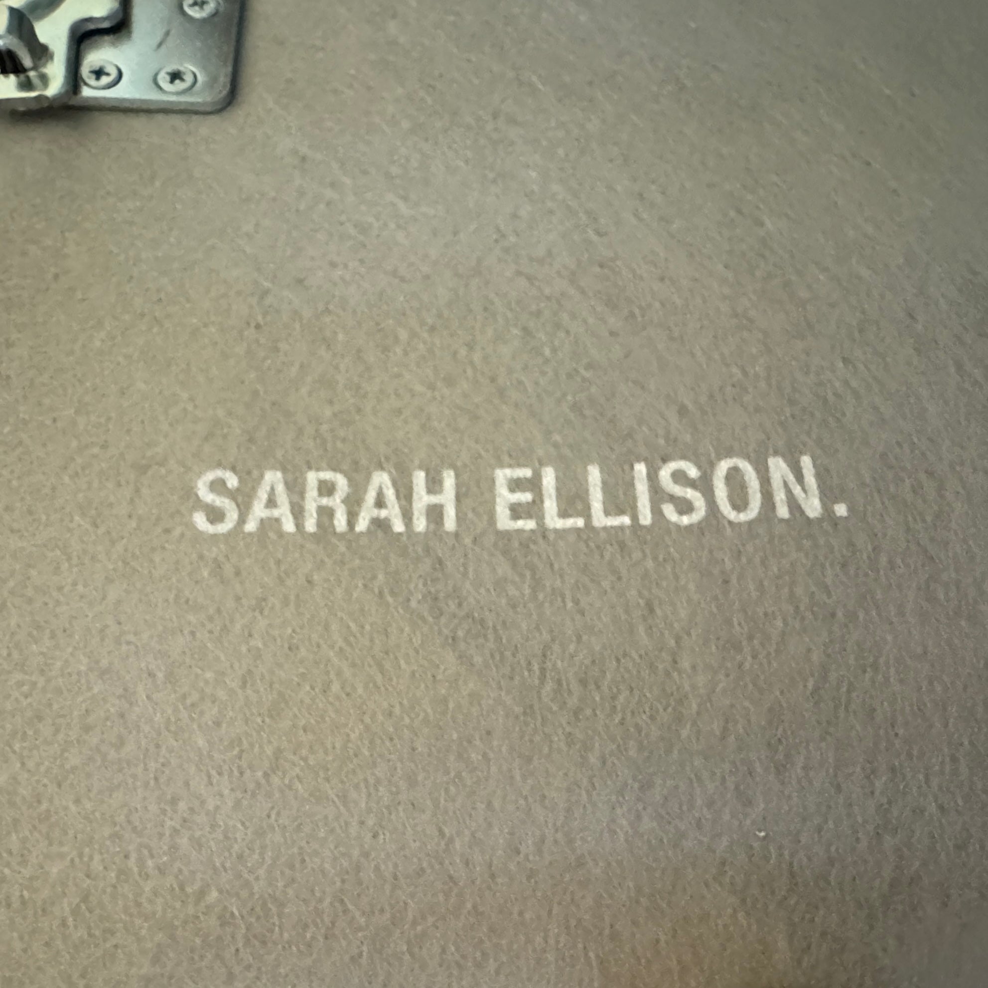 The Ellison Studios “Muse” Sofa Two Seater, in modern beige with plush rounded cushions and arms, channels Sarah Ellison’s signature style, shown here on a polished concrete floor against a plain light wall.