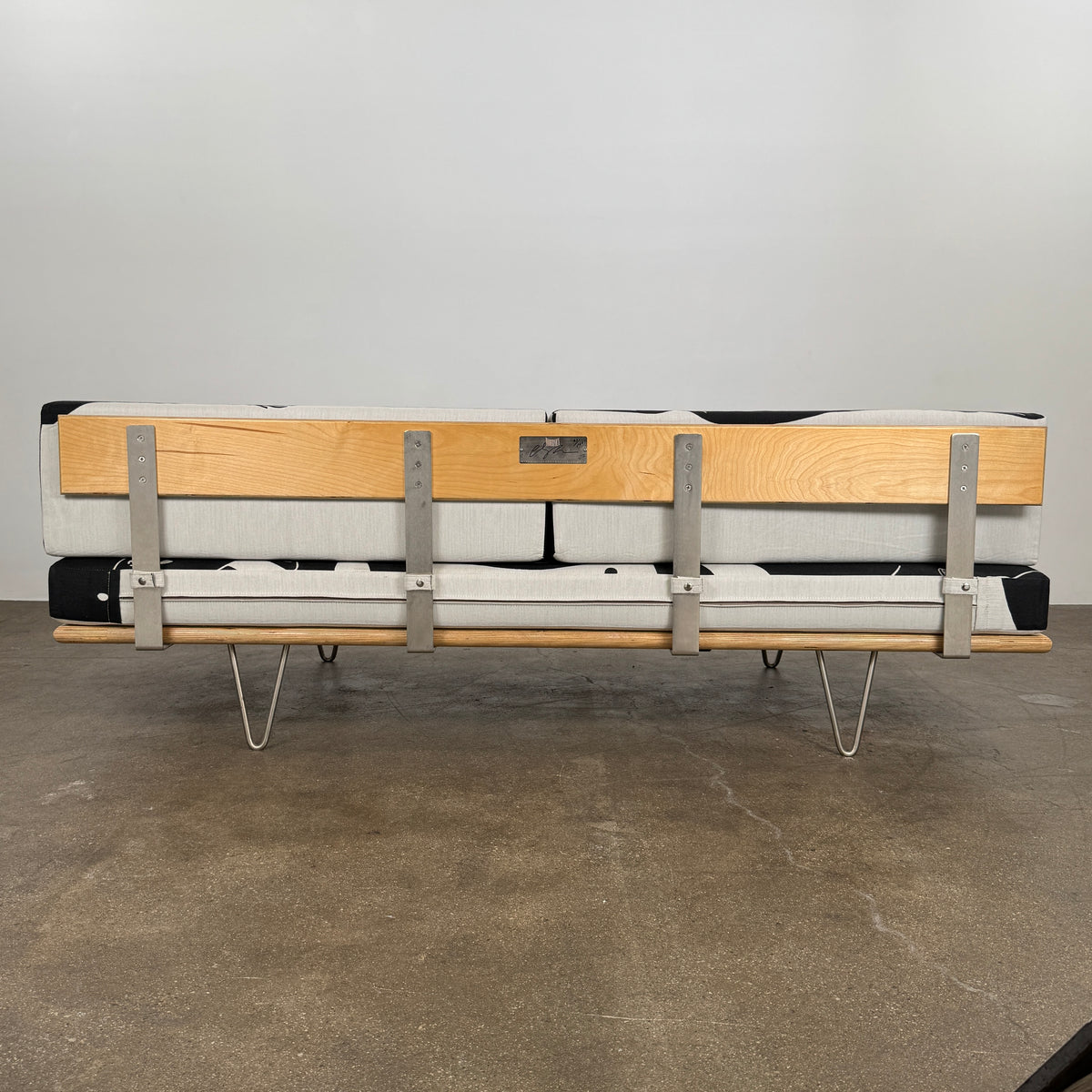 The Limited Edition Modernica + Cleon Peterson Case Study Daybed 2016 features metal hairpin legs and black-and-white cushions with abstract human figure illustrations by Cleon Peterson.