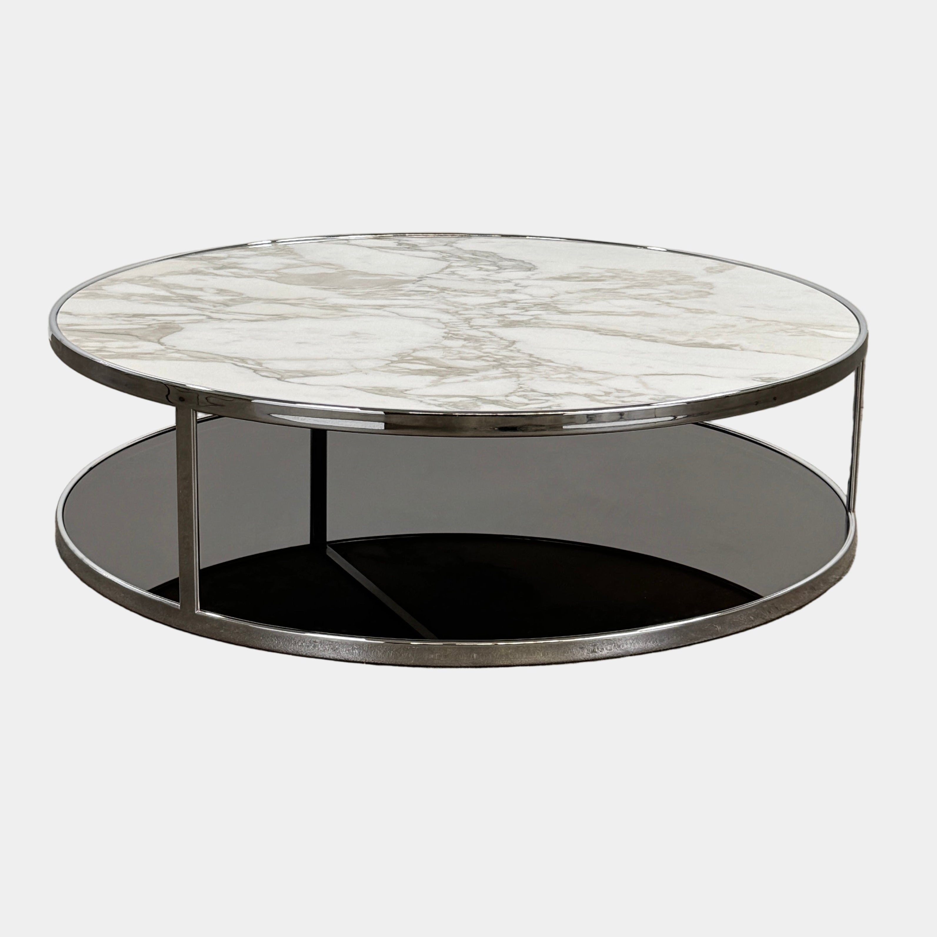 The Minotti Huber Coffee Table by Minotti features a round design with a white statuary marble top, dark lower shelf, and sleek metal frame, set against a plain light background.