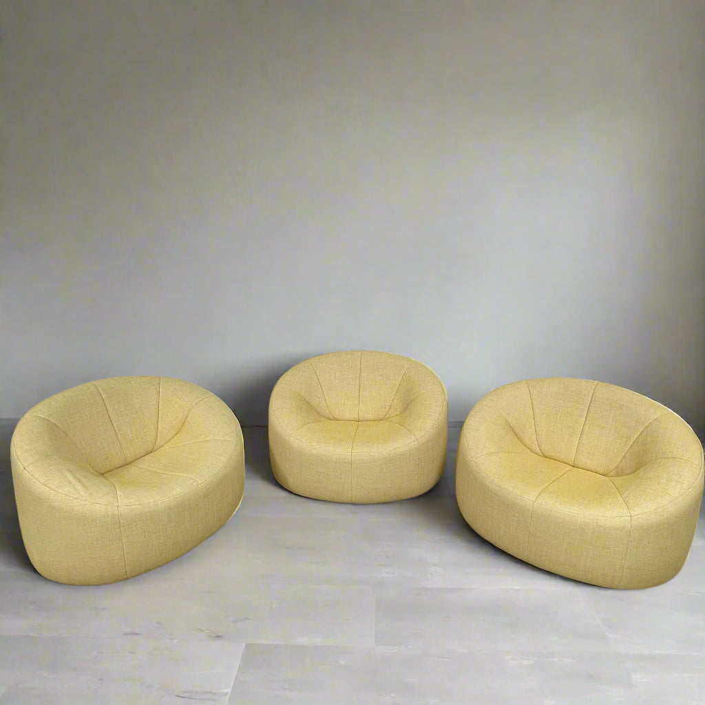 A light yellow Ligne Roset Pumpkin Swivel Lounge Chair with a round shape, low back, and wide seat is shown against a plain white background.