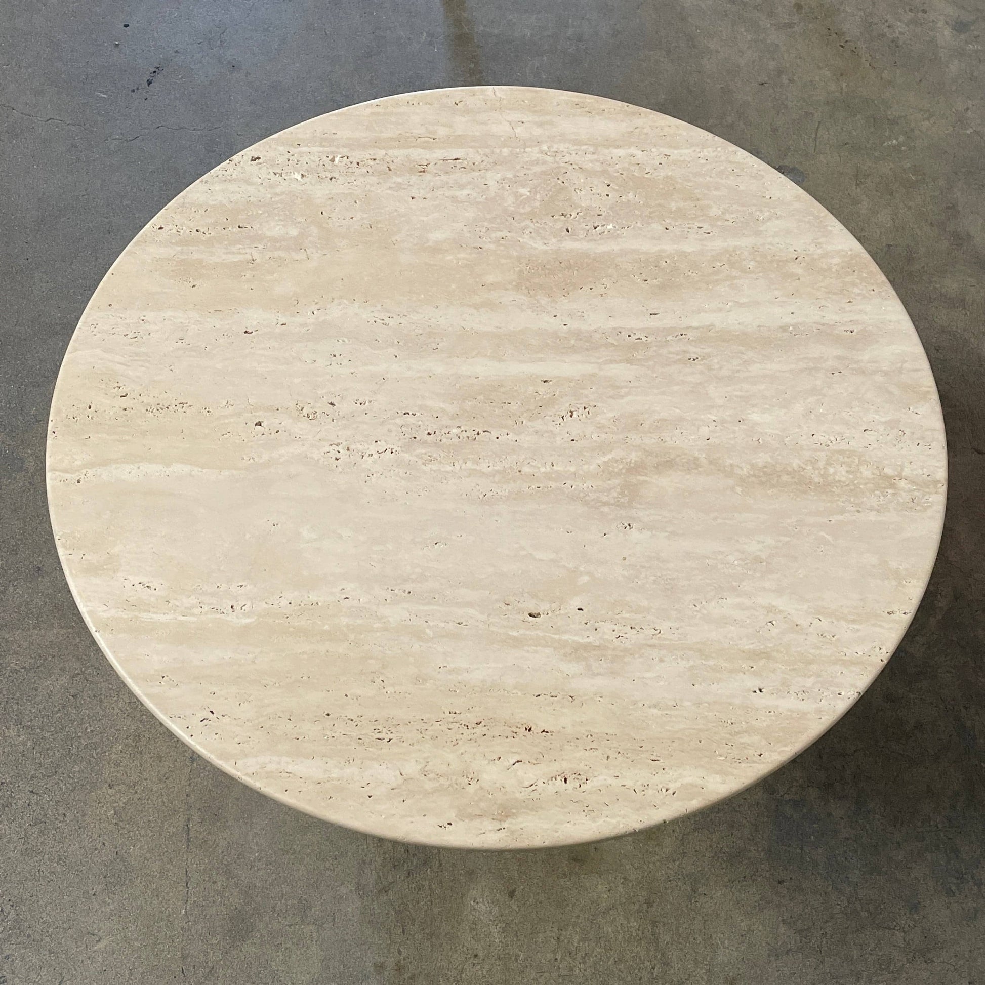 A Delcourt Collection Ouk Sylver Travertine Table, handcrafted and imported from France, is displayed on a white background.