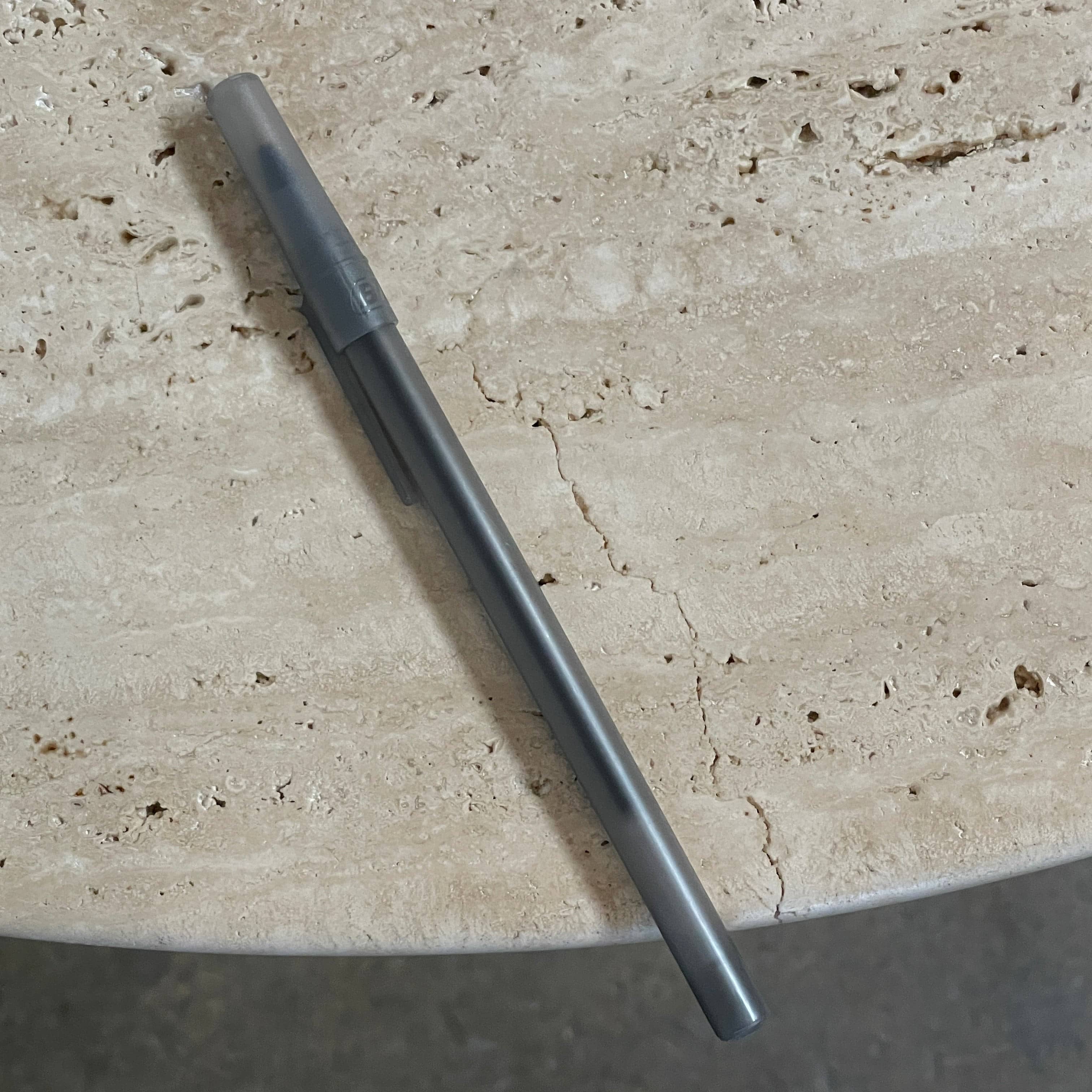 A Delcourt Collection Ouk Sylver Travertine Table, handcrafted and imported from France, is displayed on a white background.