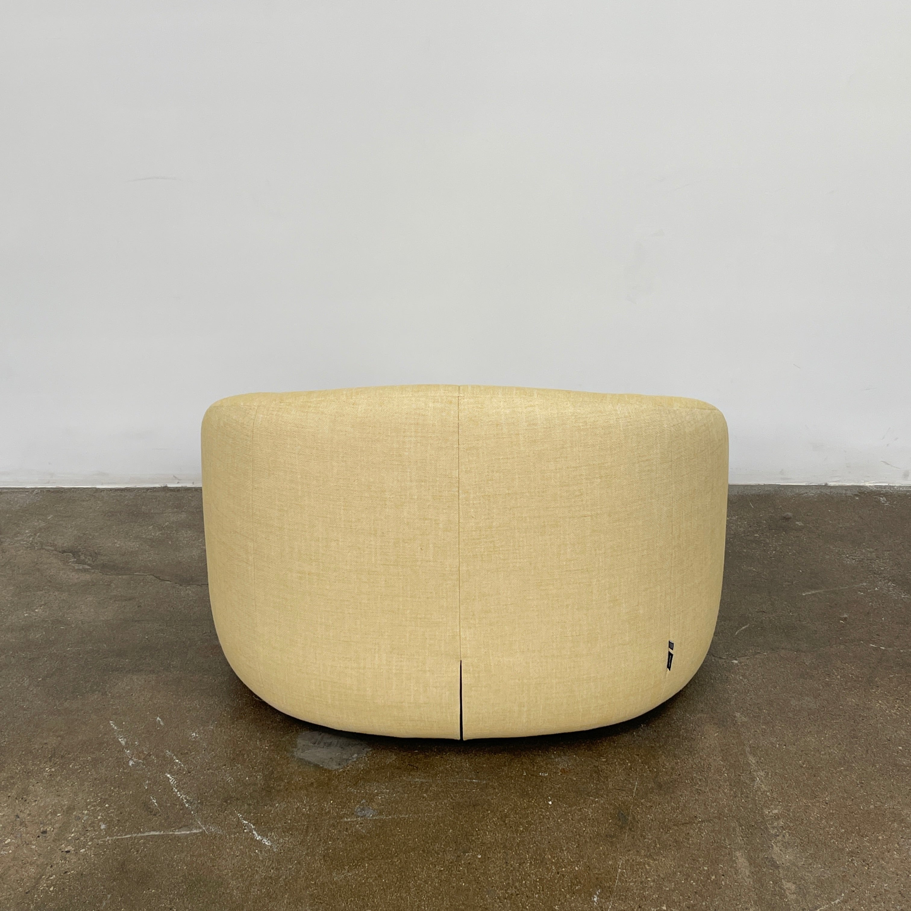 A light yellow Ligne Roset Pumpkin Swivel Lounge Chair with a round shape, low back, and wide seat is shown against a plain white background.