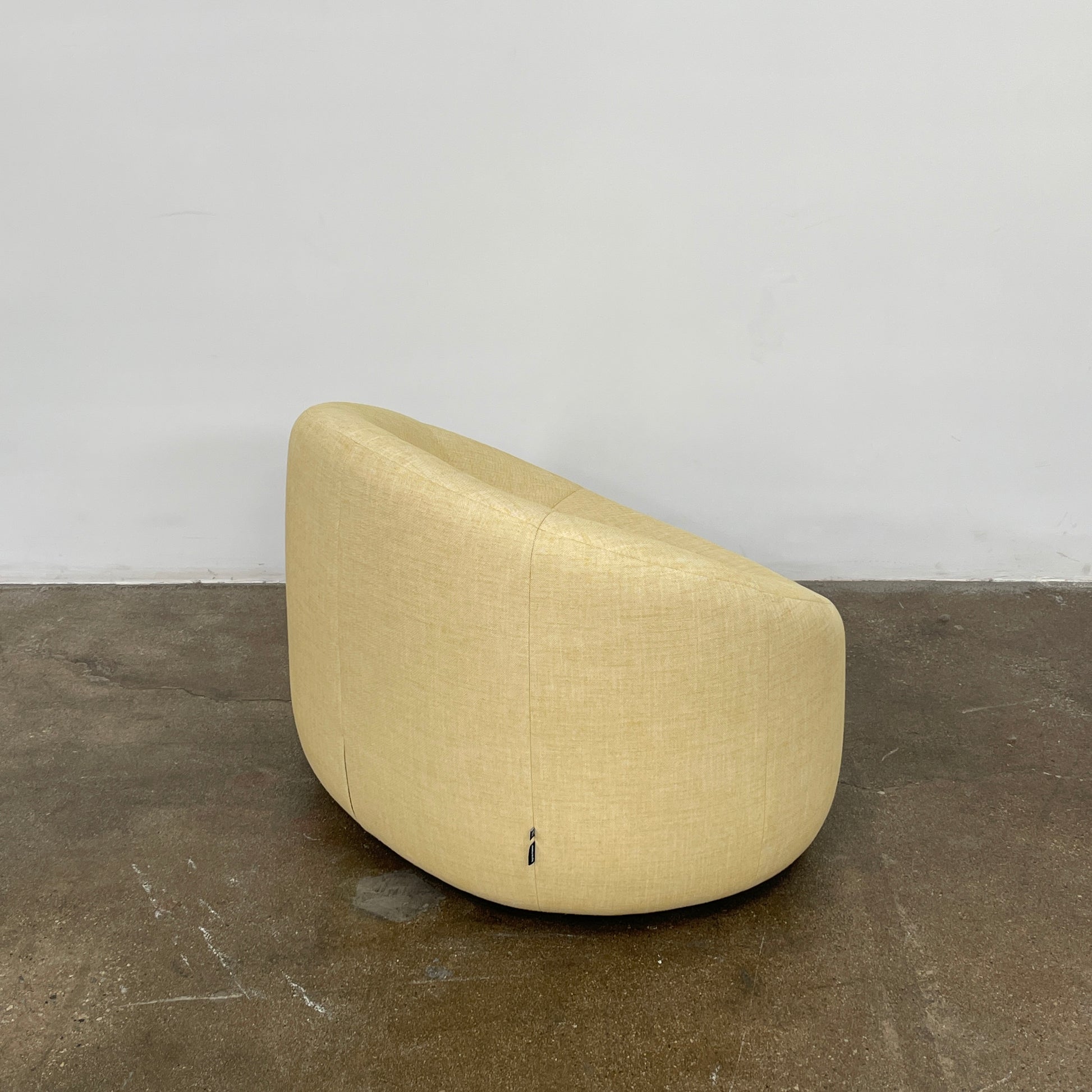 A light yellow Ligne Roset Pumpkin Swivel Lounge Chair with a round shape, low back, and wide seat is shown against a plain white background.