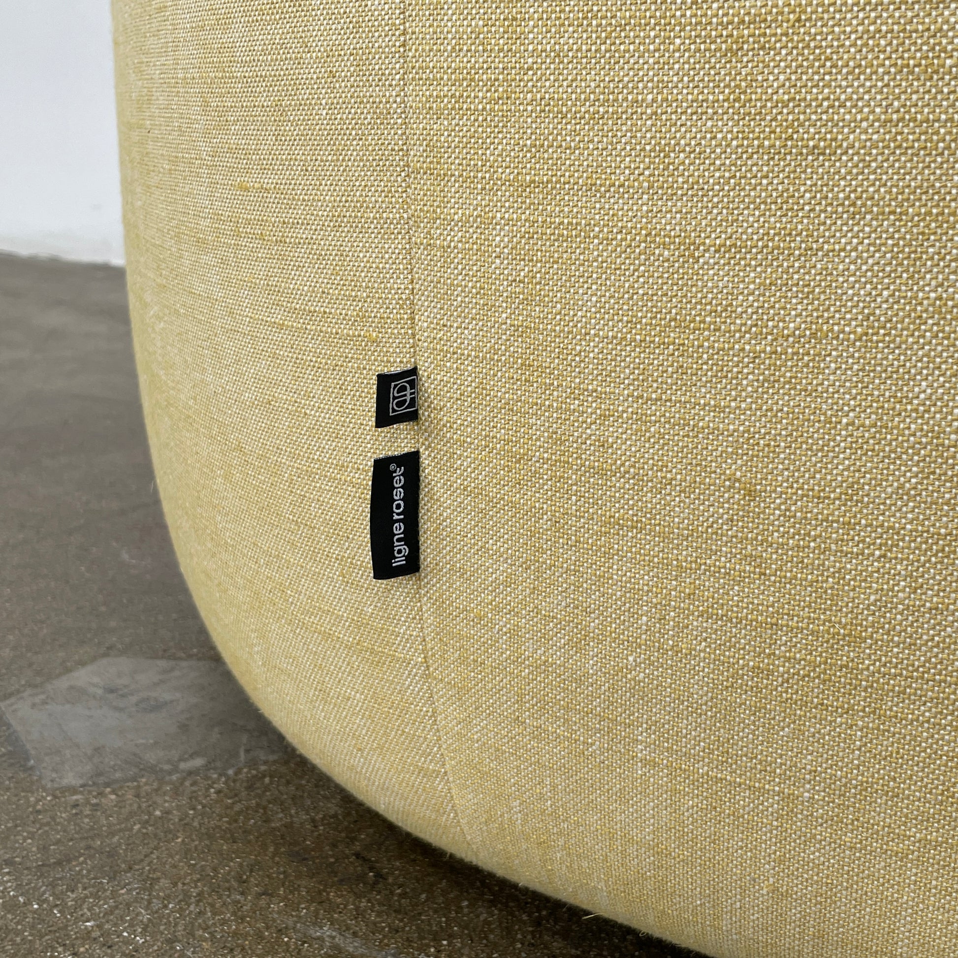 A light yellow Ligne Roset Pumpkin Swivel Lounge Chair with a round shape, low back, and wide seat is shown against a plain white background.