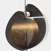 A modern chandelier with circular metal mesh panels and a central bulb hangs from a golden rod, reminiscent of the Studio M Chips 5-Light Vertical Pendant in Natural Aged Brass.