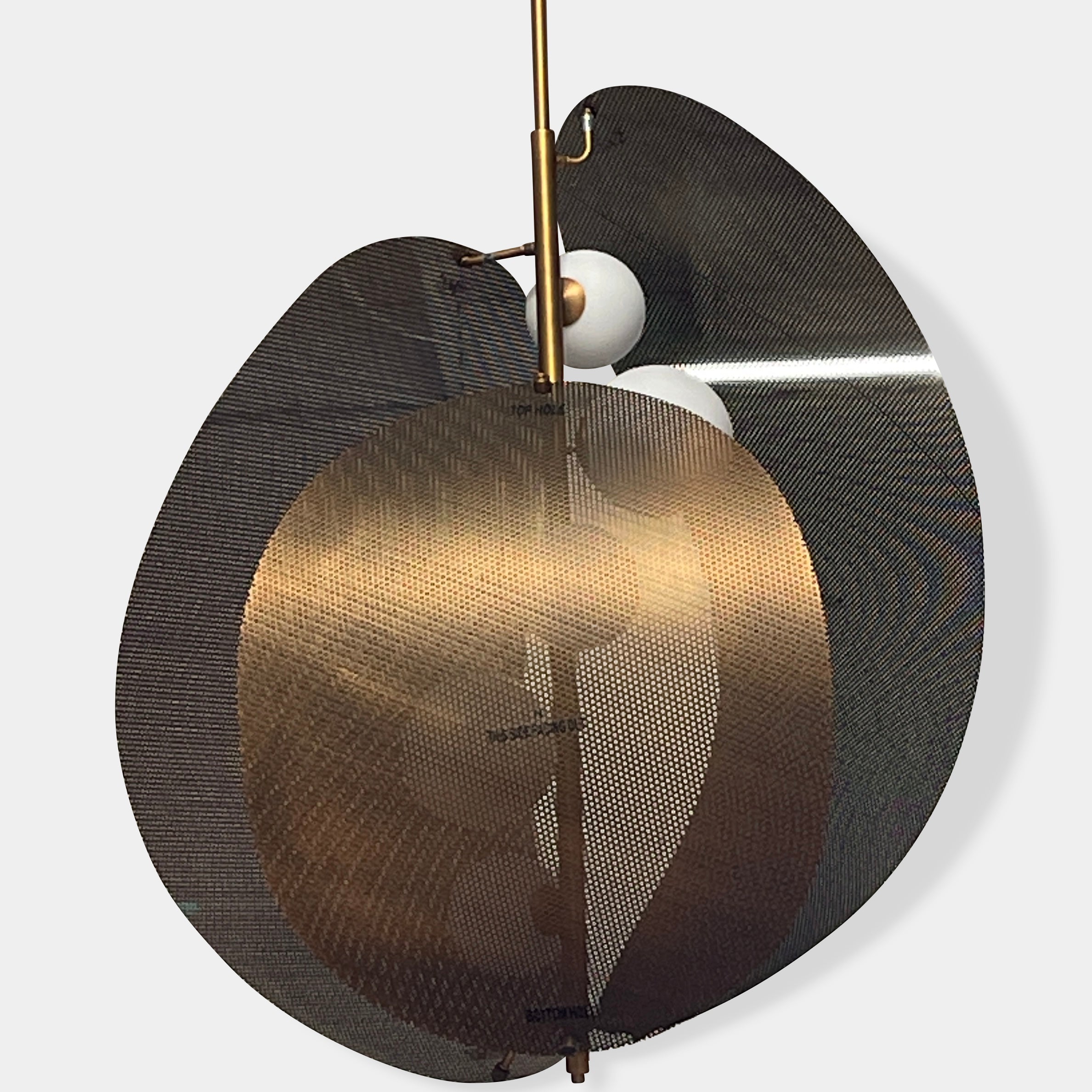 A modern chandelier with circular metal mesh panels and a central bulb hangs from a golden rod, reminiscent of the Studio M Chips 5-Light Vertical Pendant in Natural Aged Brass.