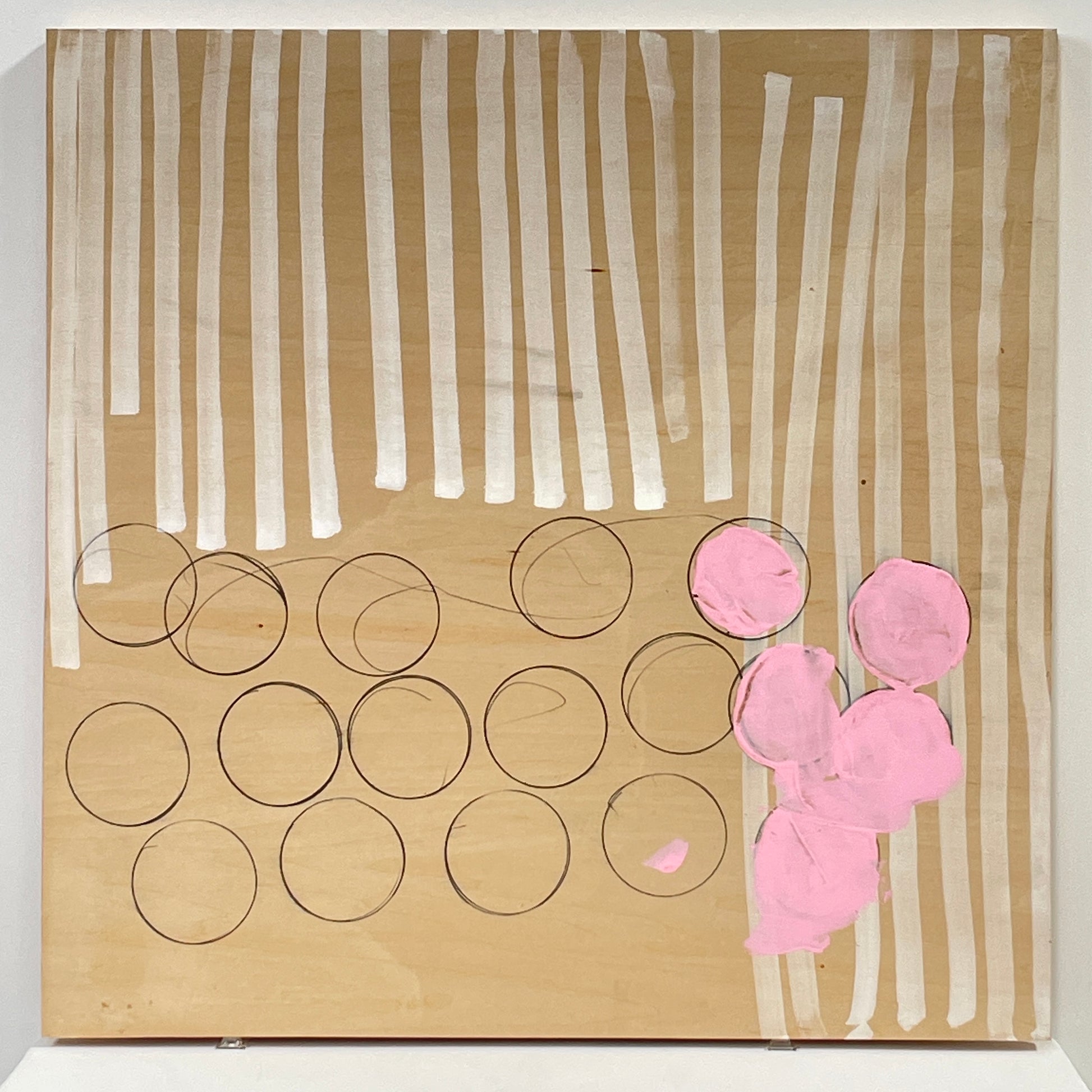 The experimental art piece "Switch" by Allison Caesar showcases vertical white lines, circular outlines, and pink patches on a wooden background.