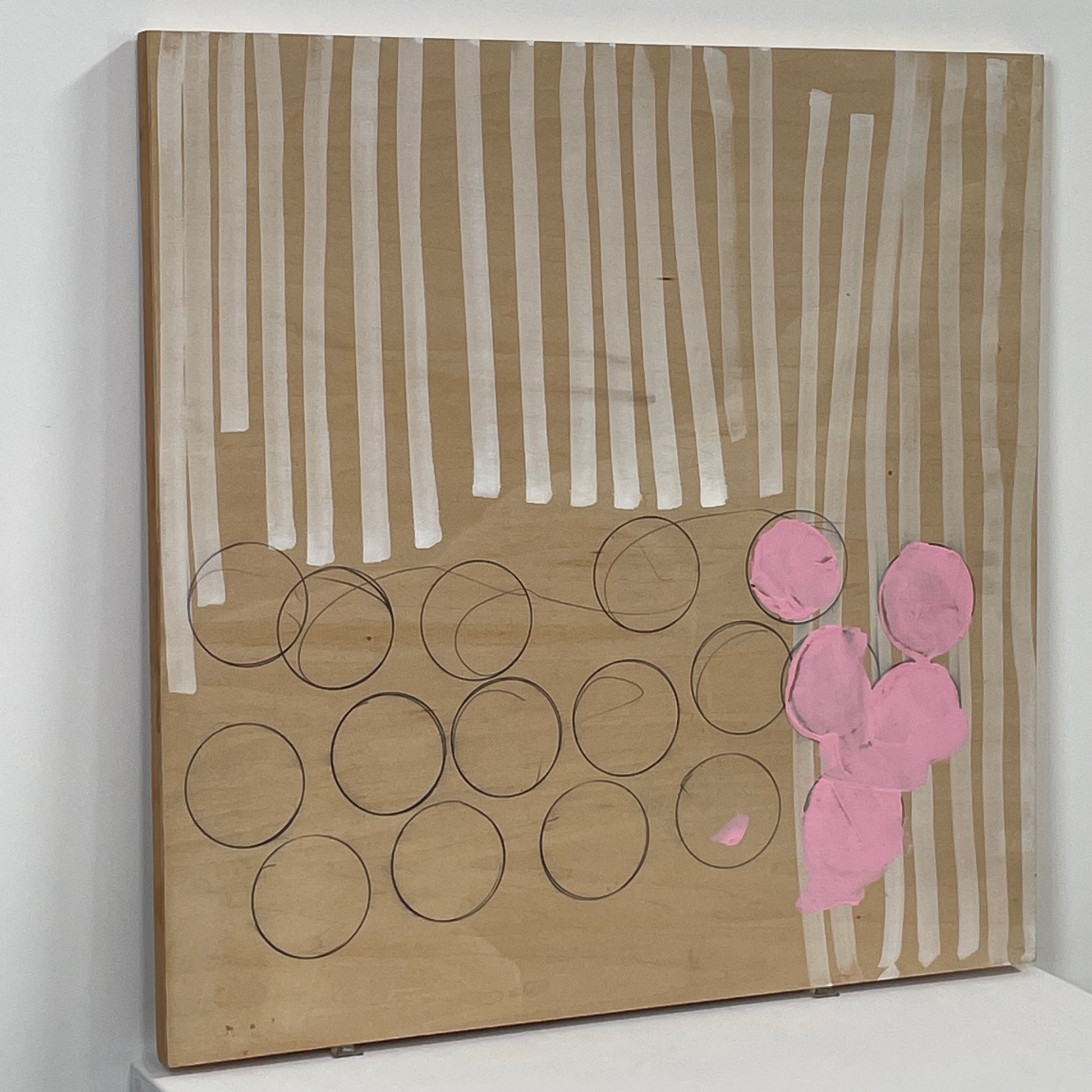 The experimental art piece "Switch" by Allison Caesar showcases vertical white lines, circular outlines, and pink patches on a wooden background.