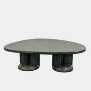 A low, irregularly shaped dark green Ian Felton Studio Mullunu Coffee Table with three thick, cylindrical legs stands on a plain white background.