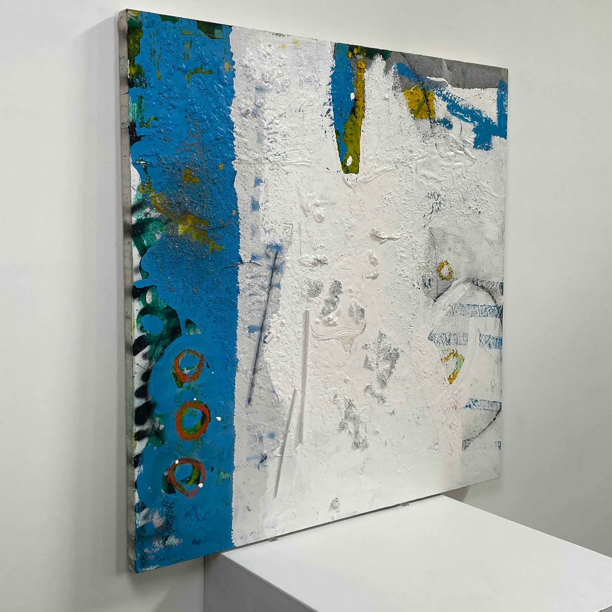 Artist's 'Painting: Variation' by Allison Caesar showcases textured layers of white, blue, with subtle yellow and green. Circular patterns on the left blend collage elements, mixing paint with relief details.