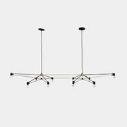 Two Ravenhill Studio Double Church Chandeliers by Ravenhill Studio, featuring exposed bulbs and modern black metal design, hang from a white industrial ceiling with visible beams, creating striking entryway lighting.