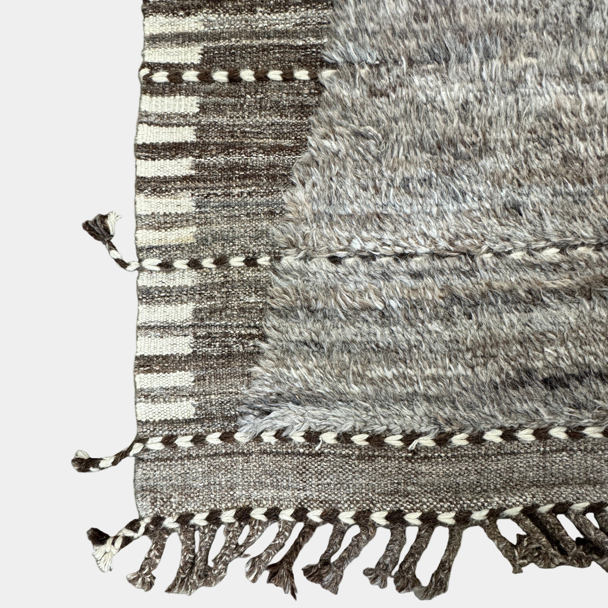 The Mehraban Gilavar Rug (13' x 15'.5") by Mehraban features handwoven, textured neutral tones, fringe tassels on the edges, and striped and patterned designs.