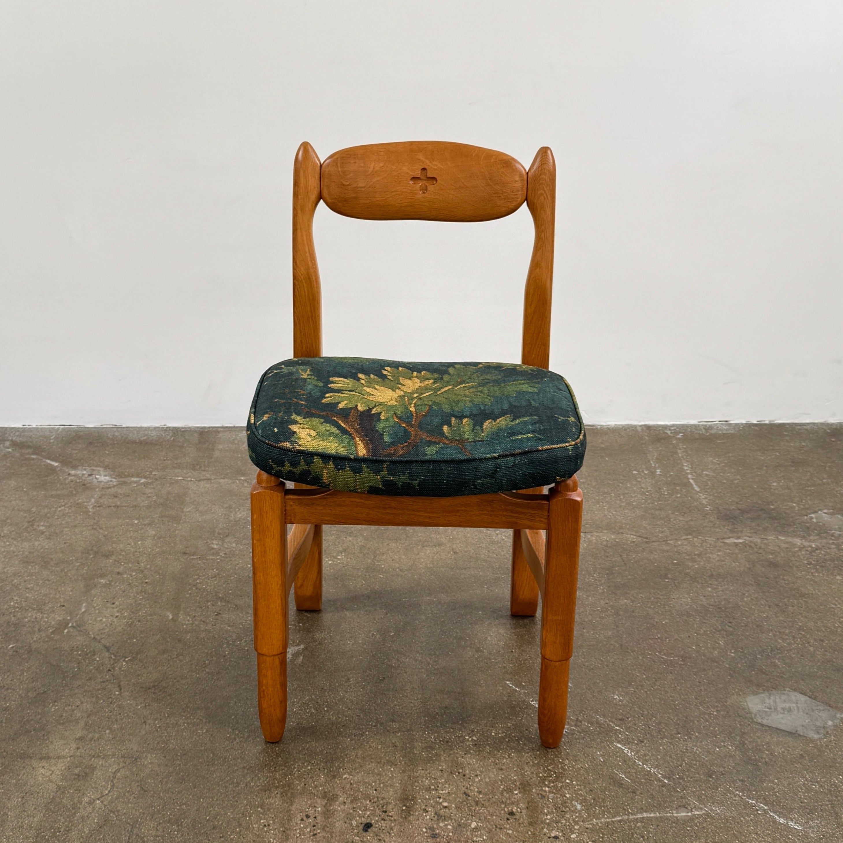 A set of 6 Vintage Votre Maison Guillerme Et Chambron dining chairs in French oak with curved backs and green floral upholstery are shown in two rows of three, highlighting postwar modernist elegance against a white background.