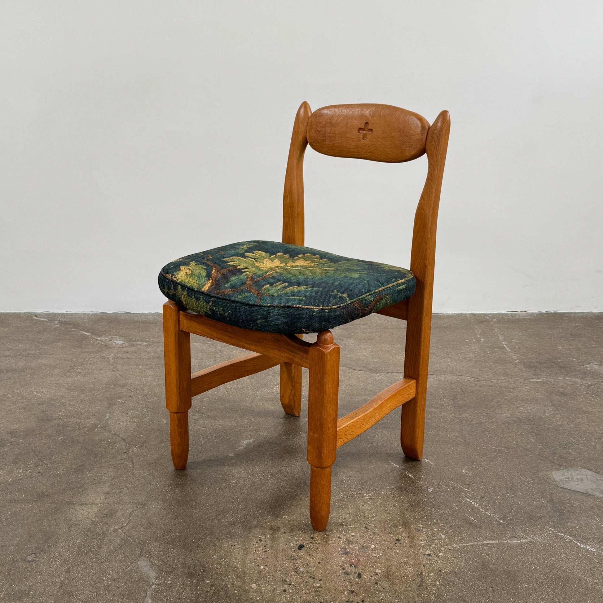A set of 6 Vintage Votre Maison Guillerme Et Chambron dining chairs in French oak with curved backs and green floral upholstery are shown in two rows of three, highlighting postwar modernist elegance against a white background.