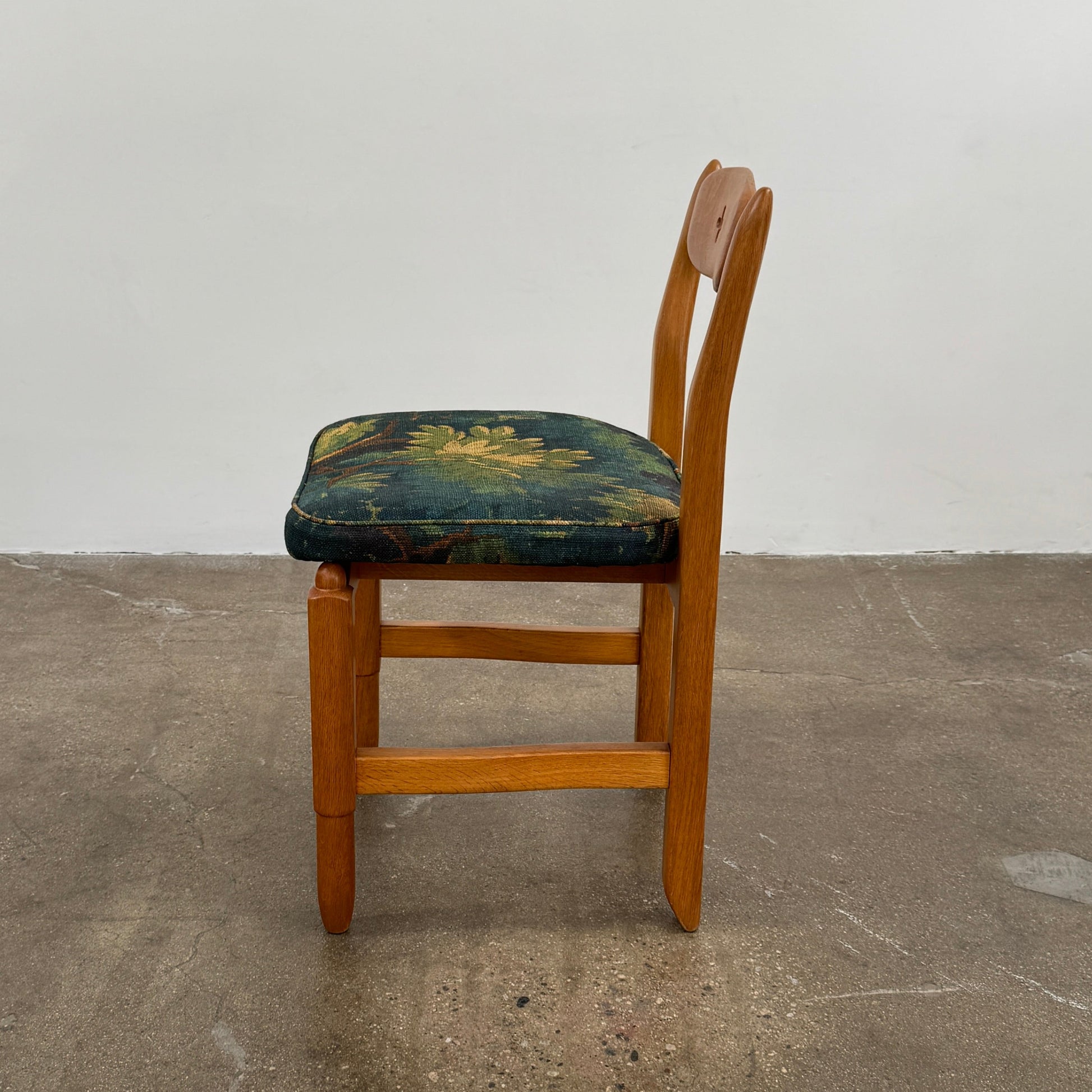 A set of 6 Vintage Votre Maison Guillerme Et Chambron dining chairs in French oak with curved backs and green floral upholstery are shown in two rows of three, highlighting postwar modernist elegance against a white background.