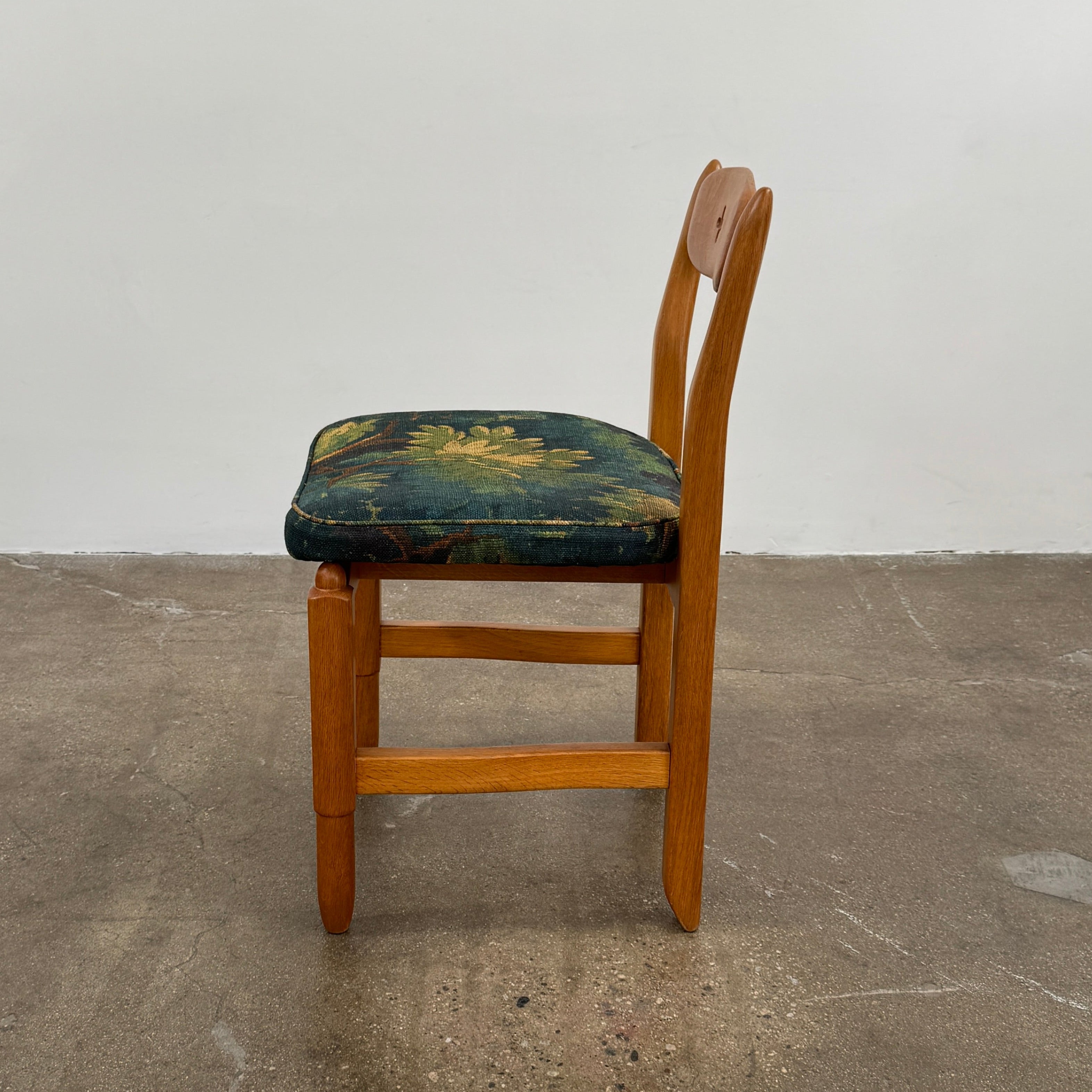 A set of 6 Vintage Votre Maison Guillerme Et Chambron dining chairs in French oak with curved backs and green floral upholstery are shown in two rows of three, highlighting postwar modernist elegance against a white background.