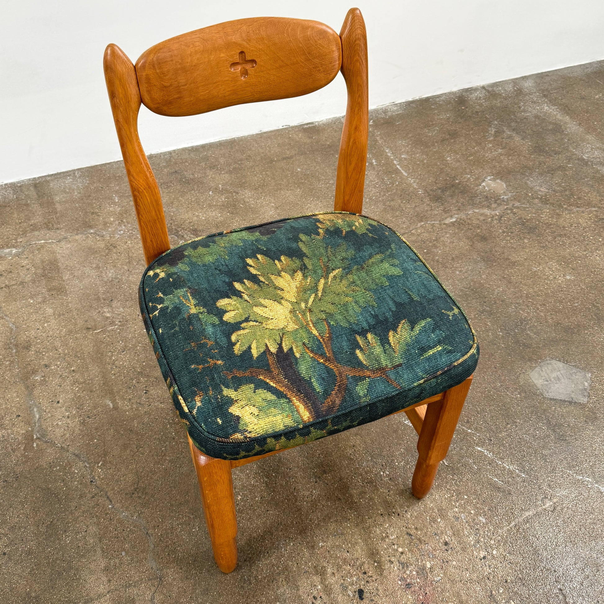 A set of 6 Vintage Votre Maison Guillerme Et Chambron dining chairs in French oak with curved backs and green floral upholstery are shown in two rows of three, highlighting postwar modernist elegance against a white background.