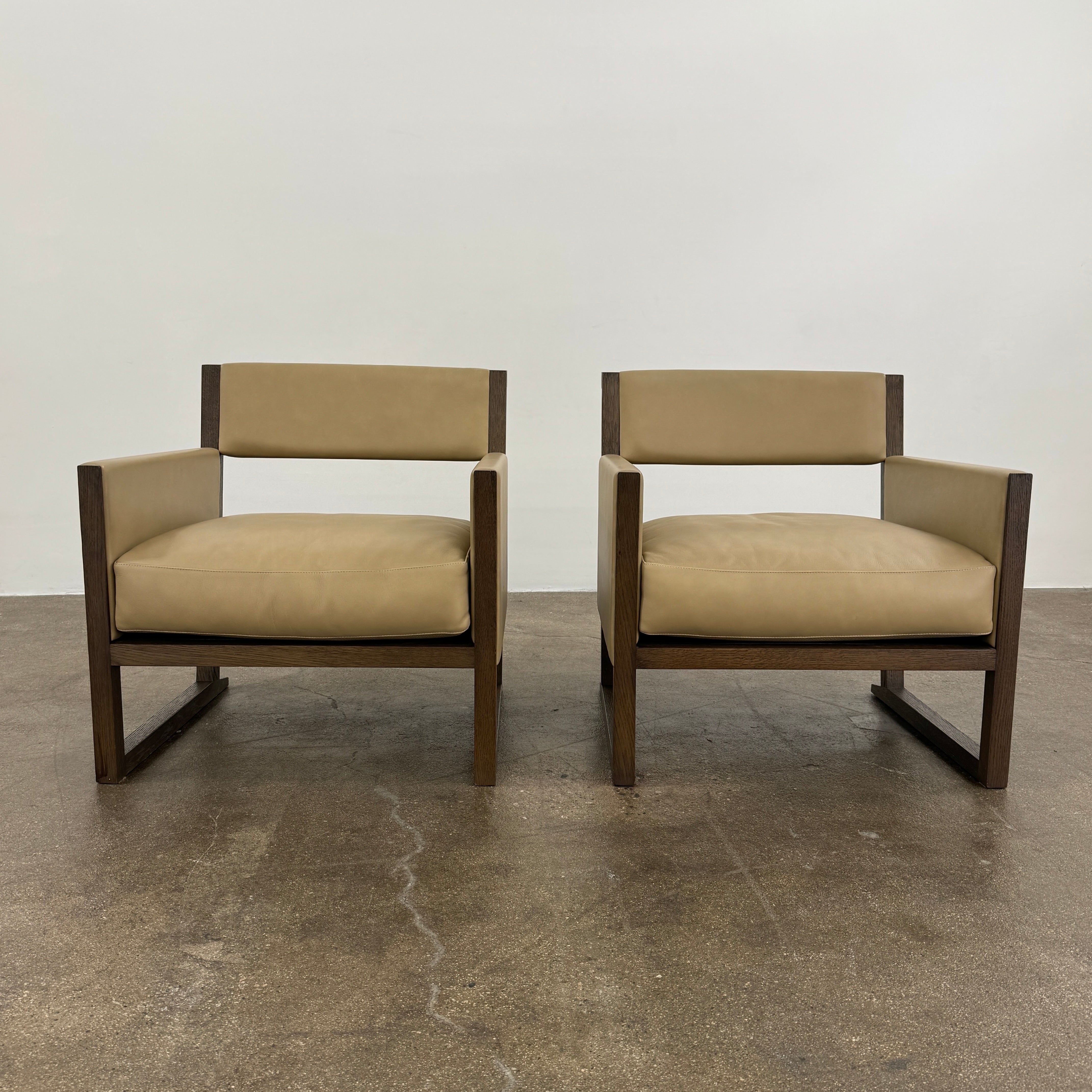 The Maxalto Musa Armchair features a light brown top-grain leather seat and backrest, gray oak wooden frame, and square armrests, set against a plain white background.