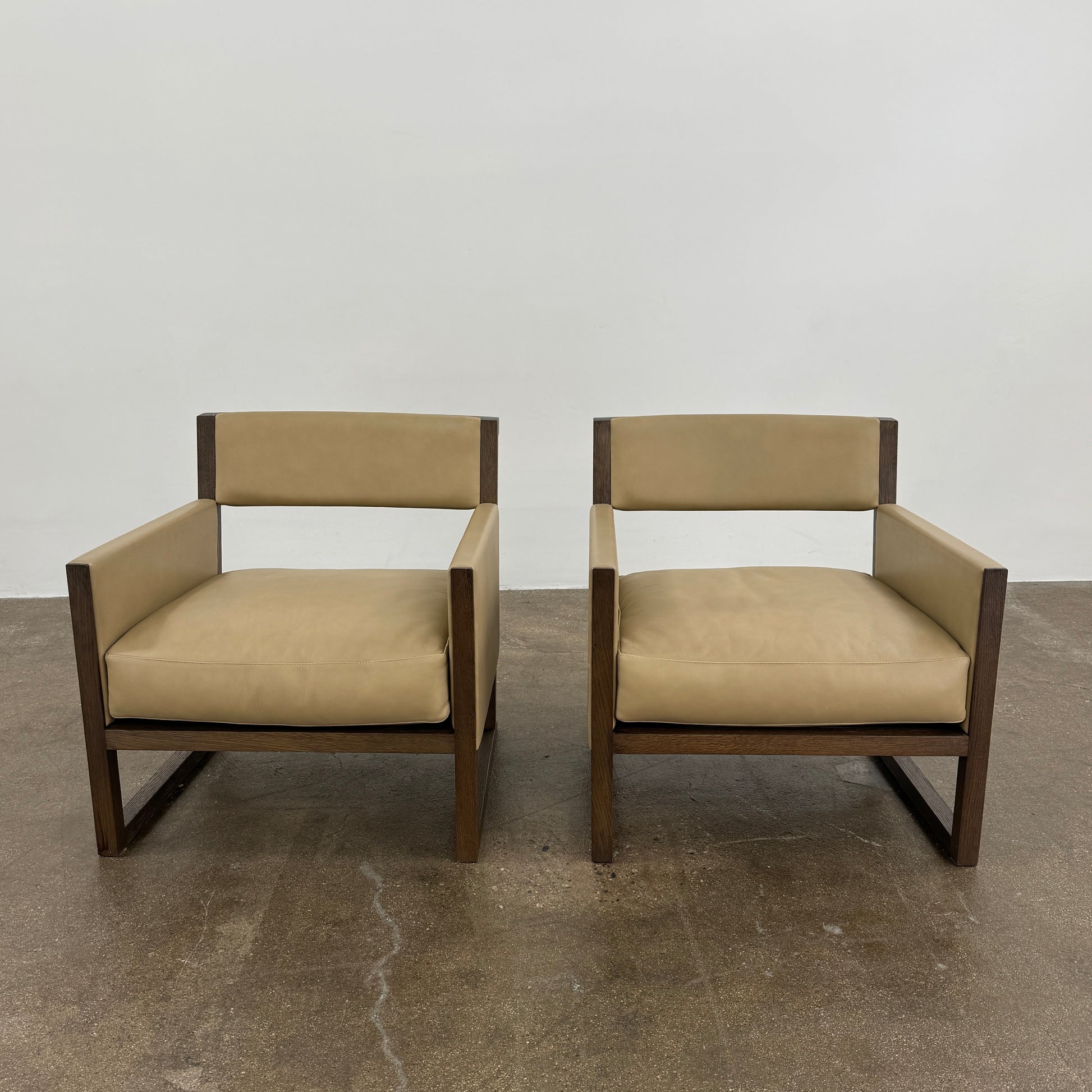 The Maxalto Musa Armchair features a light brown top-grain leather seat and backrest, gray oak wooden frame, and square armrests, set against a plain white background.