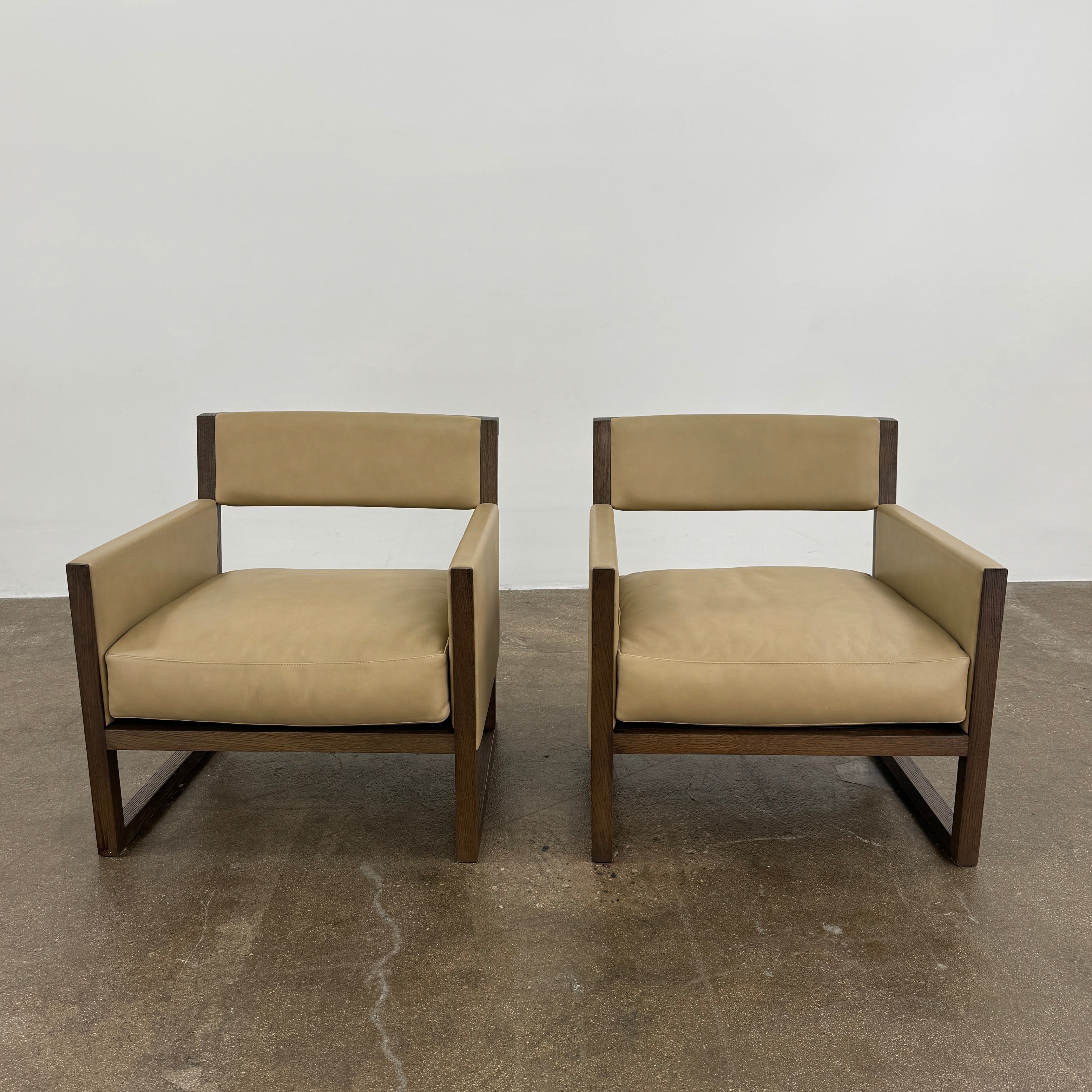 The Maxalto Musa Armchair features a light brown top-grain leather seat and backrest, gray oak wooden frame, and square armrests, set against a plain white background.