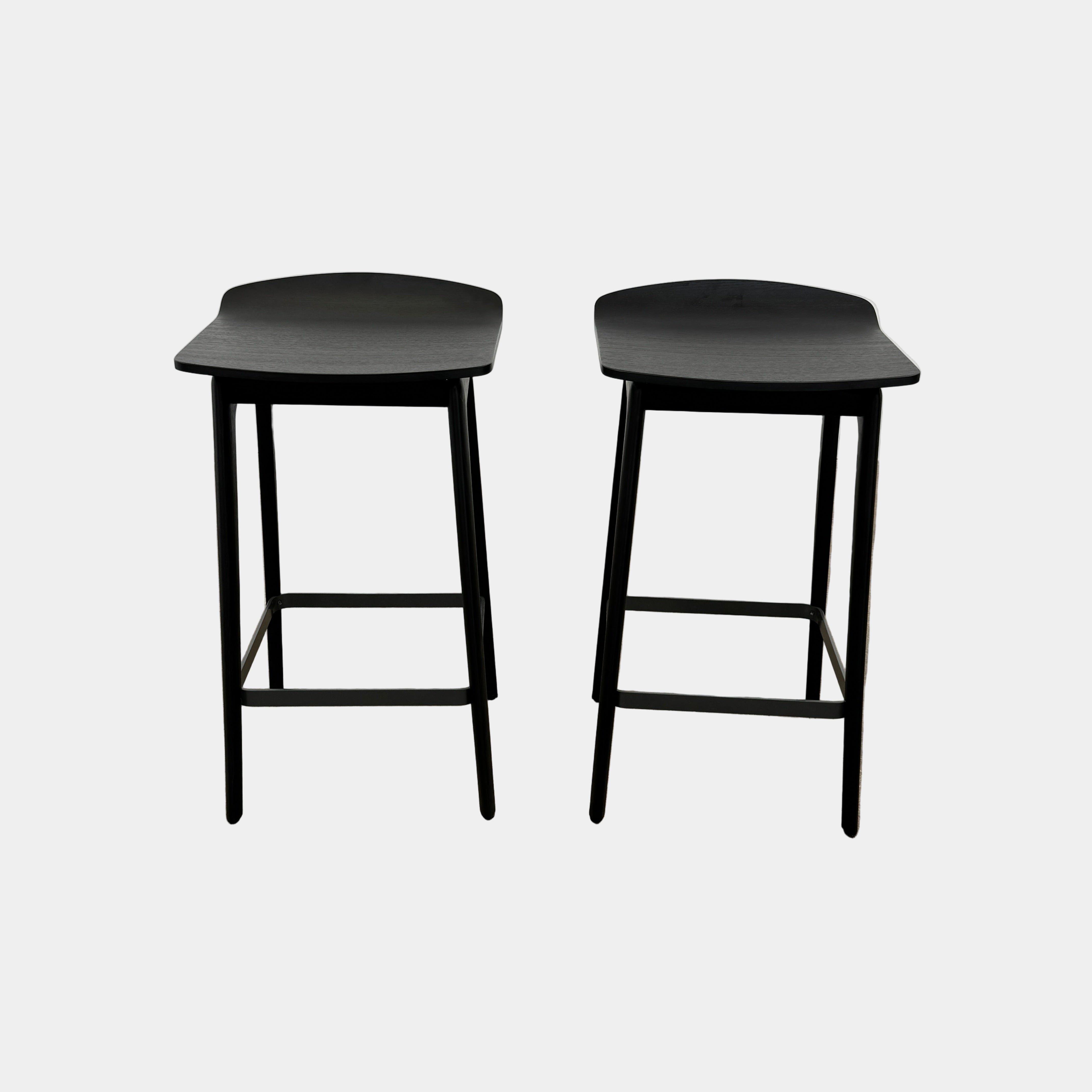 The Molteni & C Woody Kitchen Stool Set of 2 features black solid ash wood stools with curved seats and four legs, joined by support bars, shown on a plain white background.