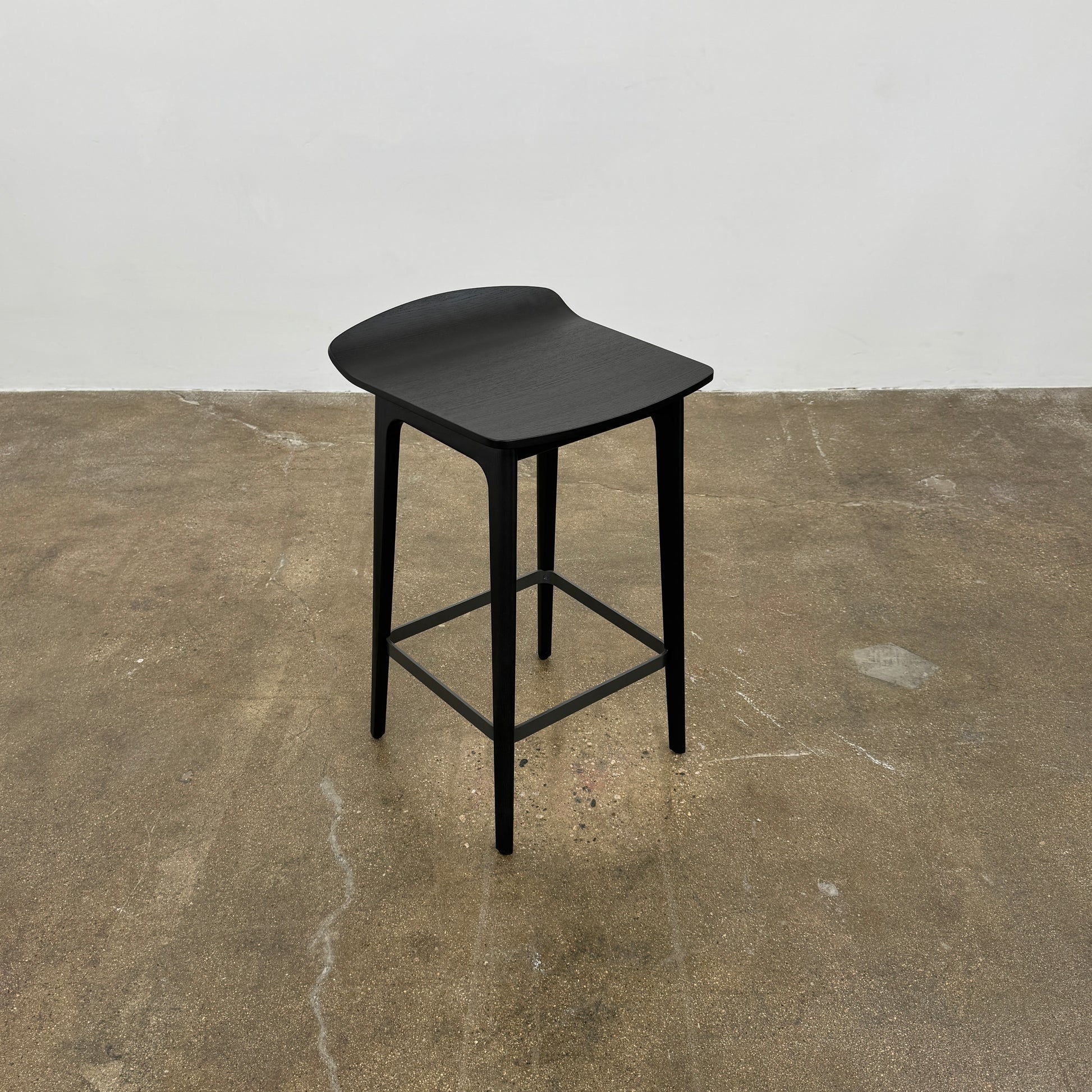 The Molteni & C Woody Kitchen Stool Set of 2 features black solid ash wood stools with curved seats and four legs, joined by support bars, shown on a plain white background.