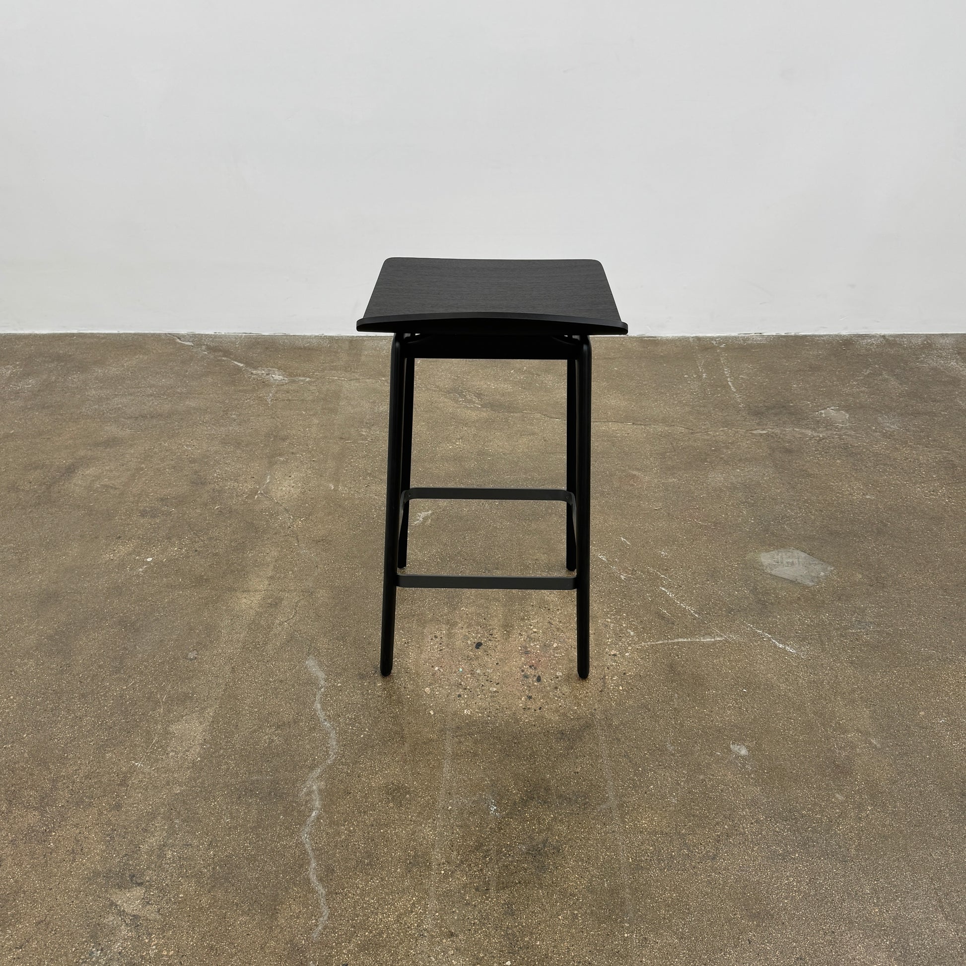 The Molteni & C Woody Kitchen Stool Set of 2 features black solid ash wood stools with curved seats and four legs, joined by support bars, shown on a plain white background.