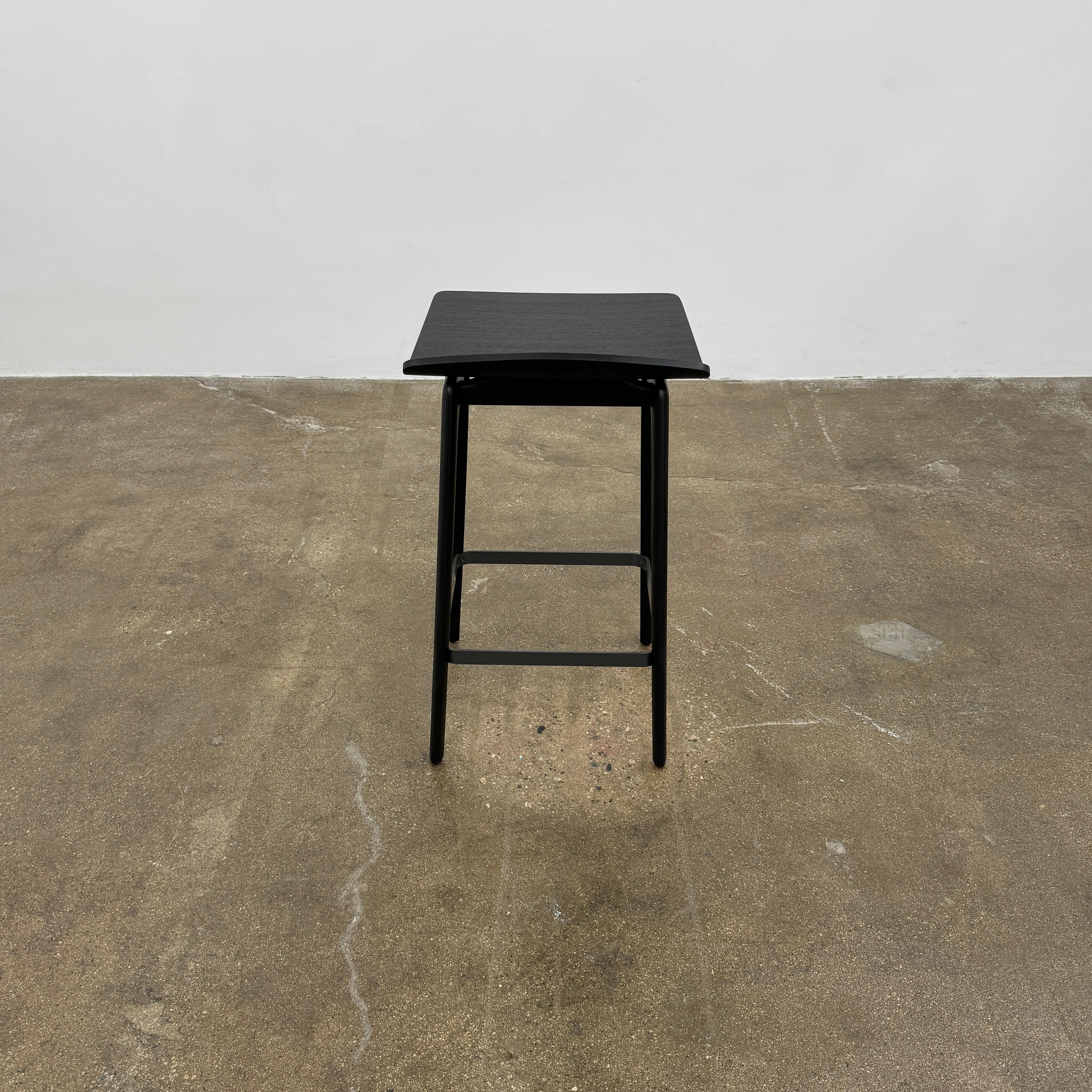The Molteni & C Woody Kitchen Stool Set of 2 features black solid ash wood stools with curved seats and four legs, joined by support bars, shown on a plain white background.