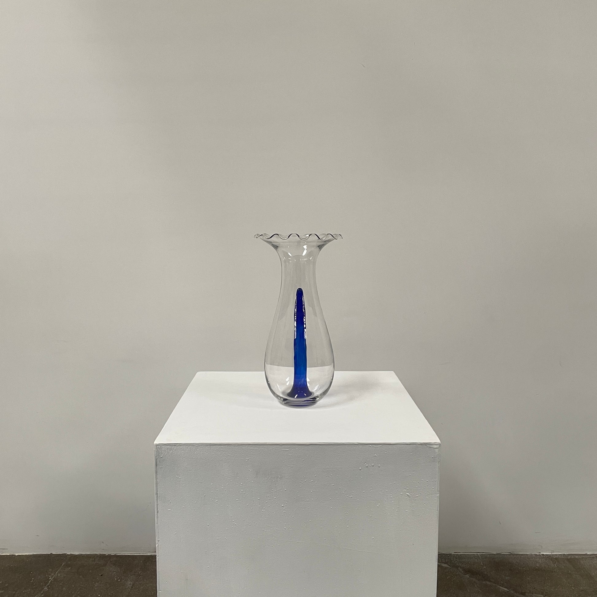 Reminiscent of Philippe Starck's elegance, the Driade Gabriel Vase by Driade showcases a wavy rim and a striking blue vertical streak within its transparent body, capturing sophisticated simplicity.