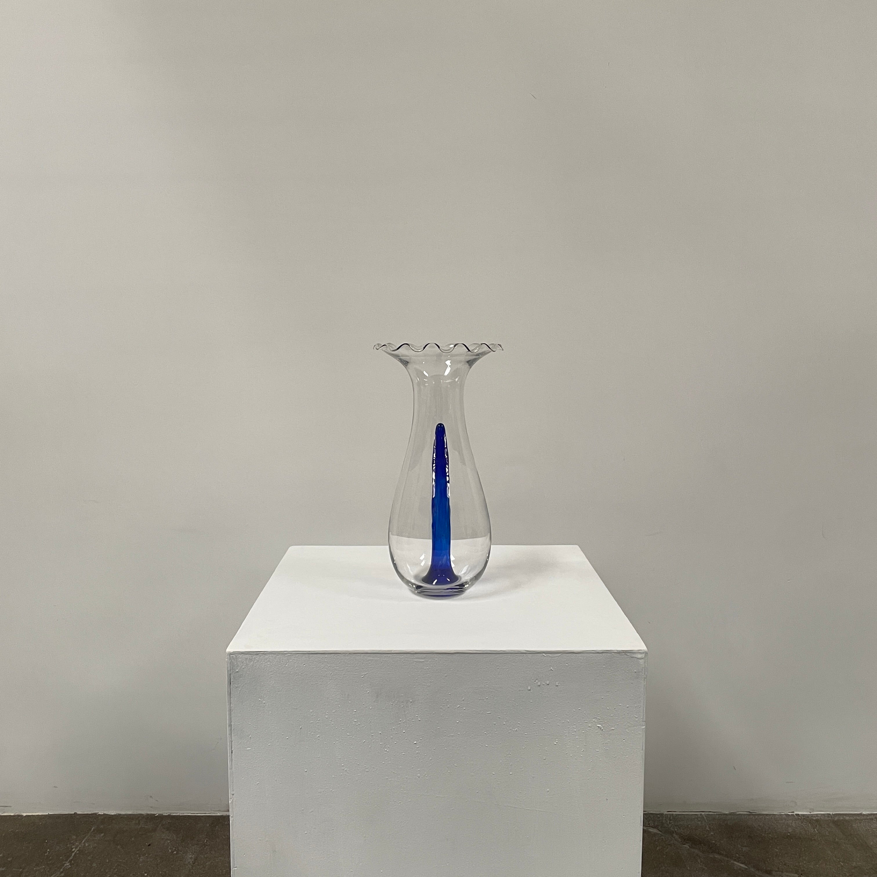 Reminiscent of Philippe Starck's elegance, the Driade Gabriel Vase by Driade showcases a wavy rim and a striking blue vertical streak within its transparent body, capturing sophisticated simplicity.