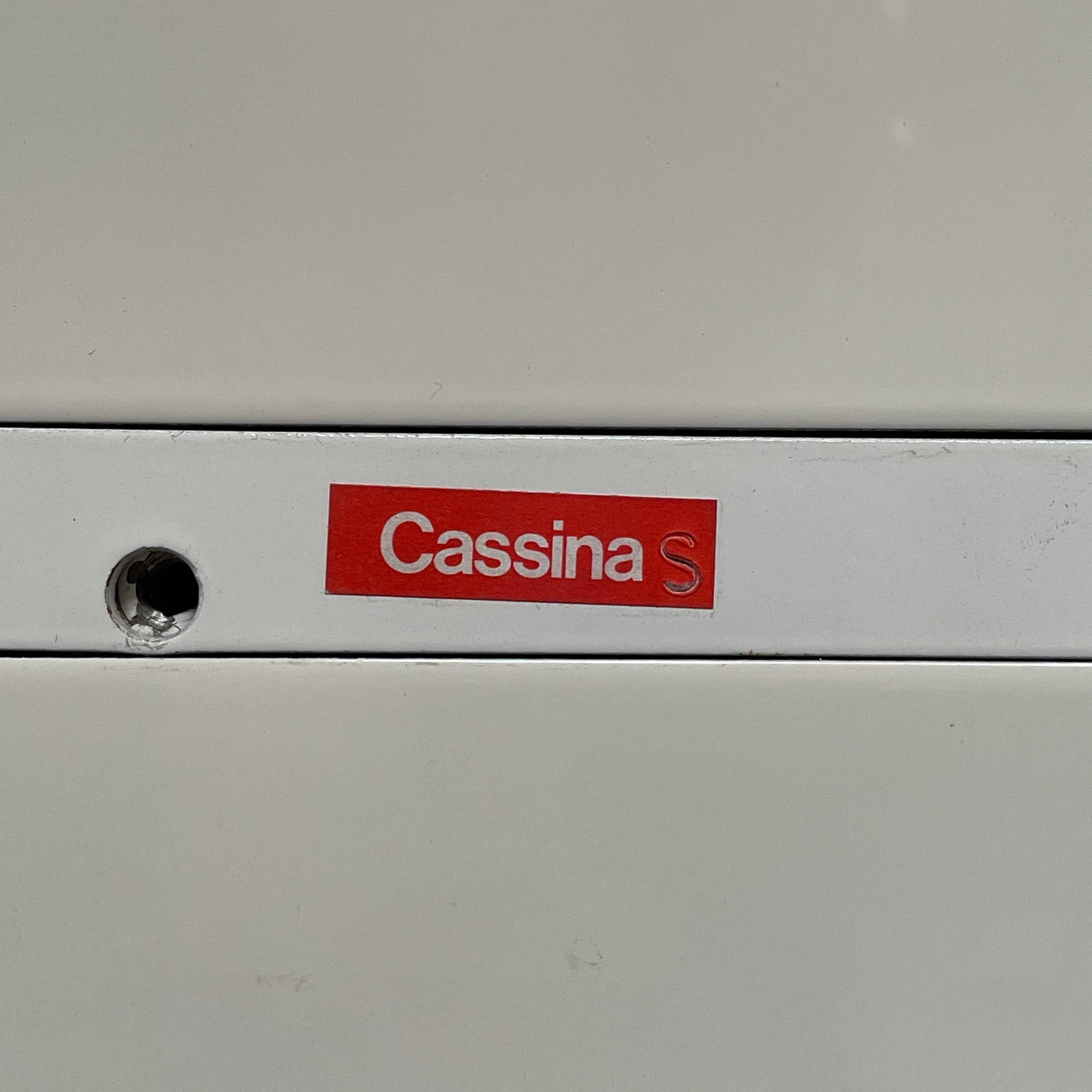 The Cassina 255-256 Flat Sideboard in glossy white lacquer features two left drawers, a spacious right compartment, and four metal legs, all by Cassina, shown against a plain background.