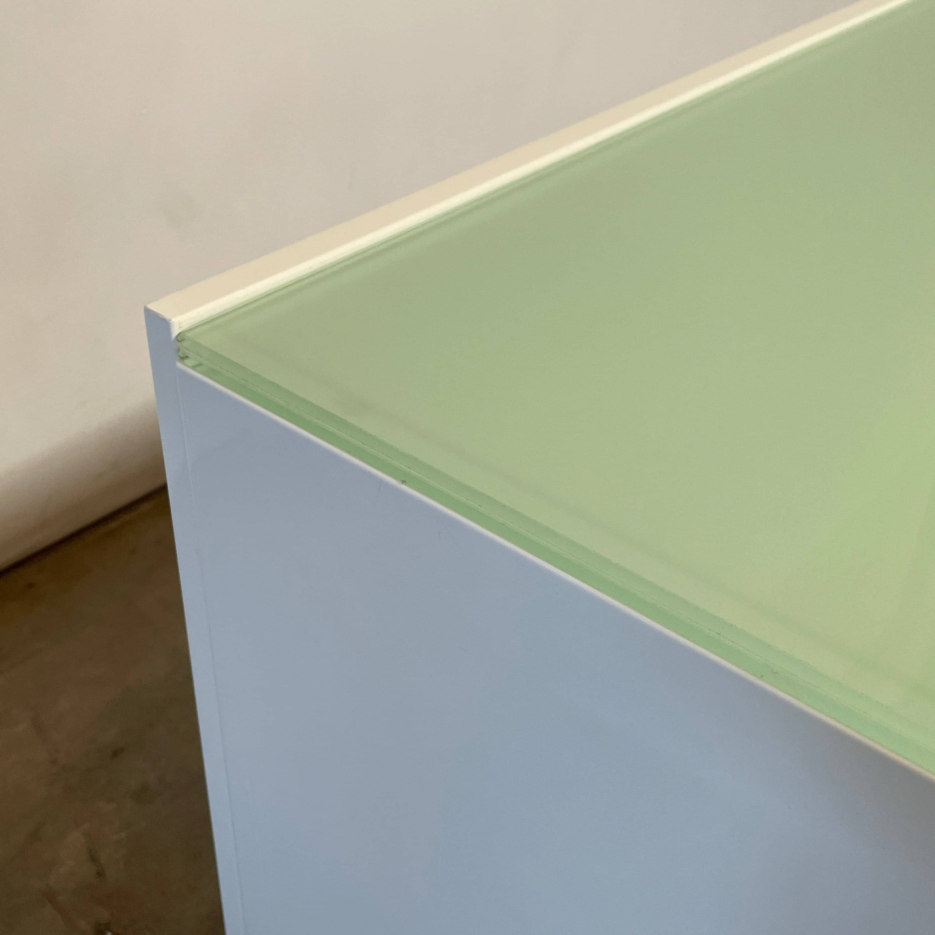 The Cassina 255-256 Flat Sideboard in glossy white lacquer features two left drawers, a spacious right compartment, and four metal legs, all by Cassina, shown against a plain background.