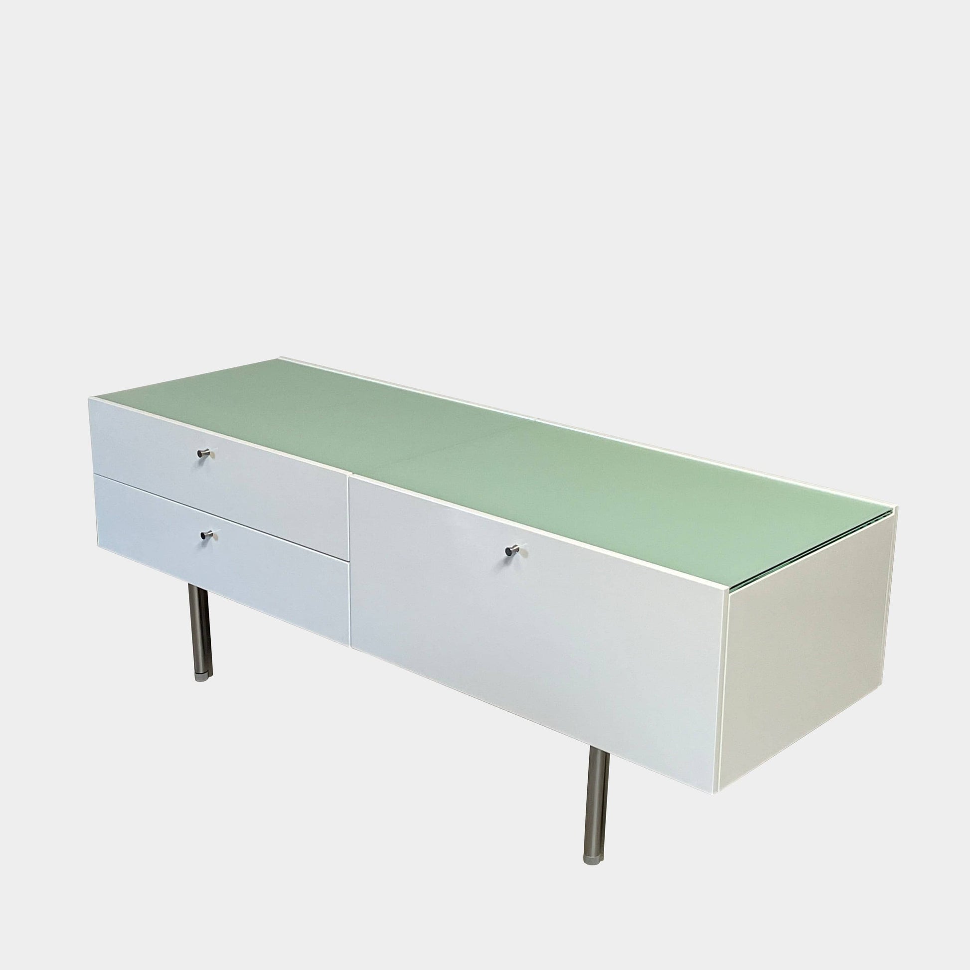 The Cassina 255-256 Flat Sideboard in glossy white lacquer features two left drawers, a spacious right compartment, and four metal legs, all by Cassina, shown against a plain background.
