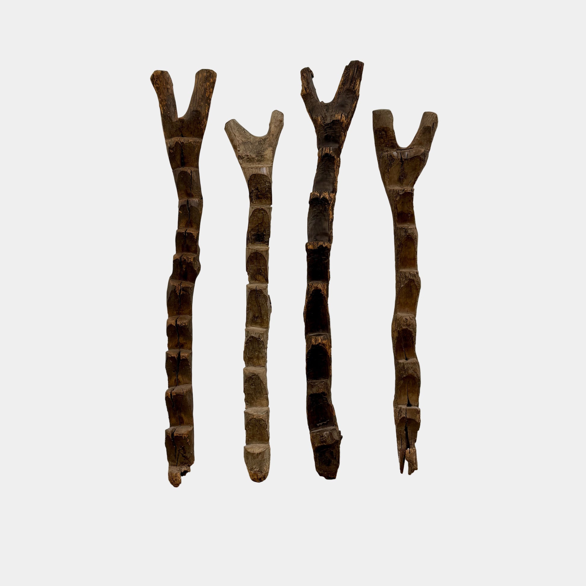 Four Vintage African Dogan Ladders, sold separately, feature wooden sticks with forked tops arranged vertically against a plain white background, showcasing distinctive African craftsmanship.
