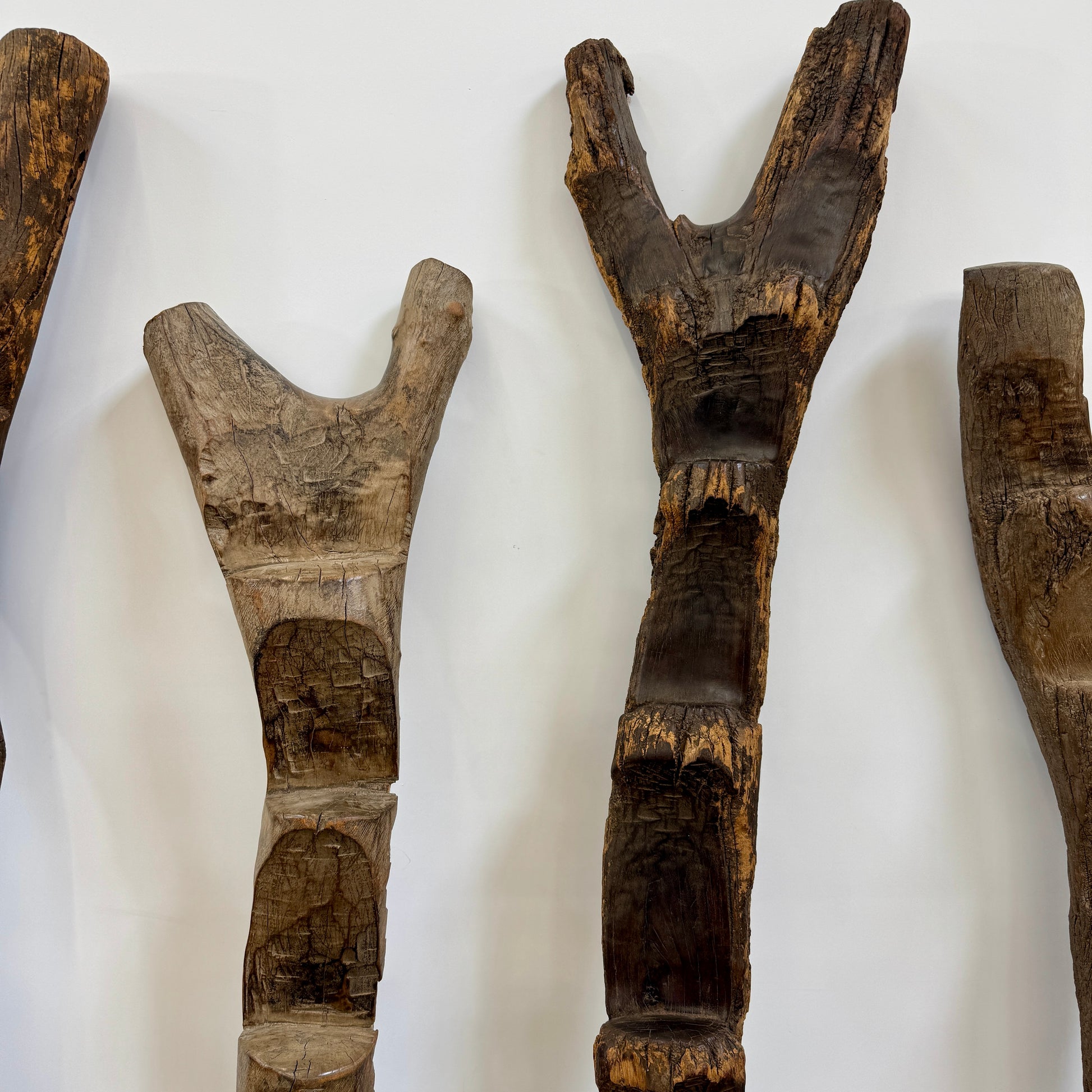 Four Vintage African Dogan Ladders, sold separately, feature wooden sticks with forked tops arranged vertically against a plain white background, showcasing distinctive African craftsmanship.