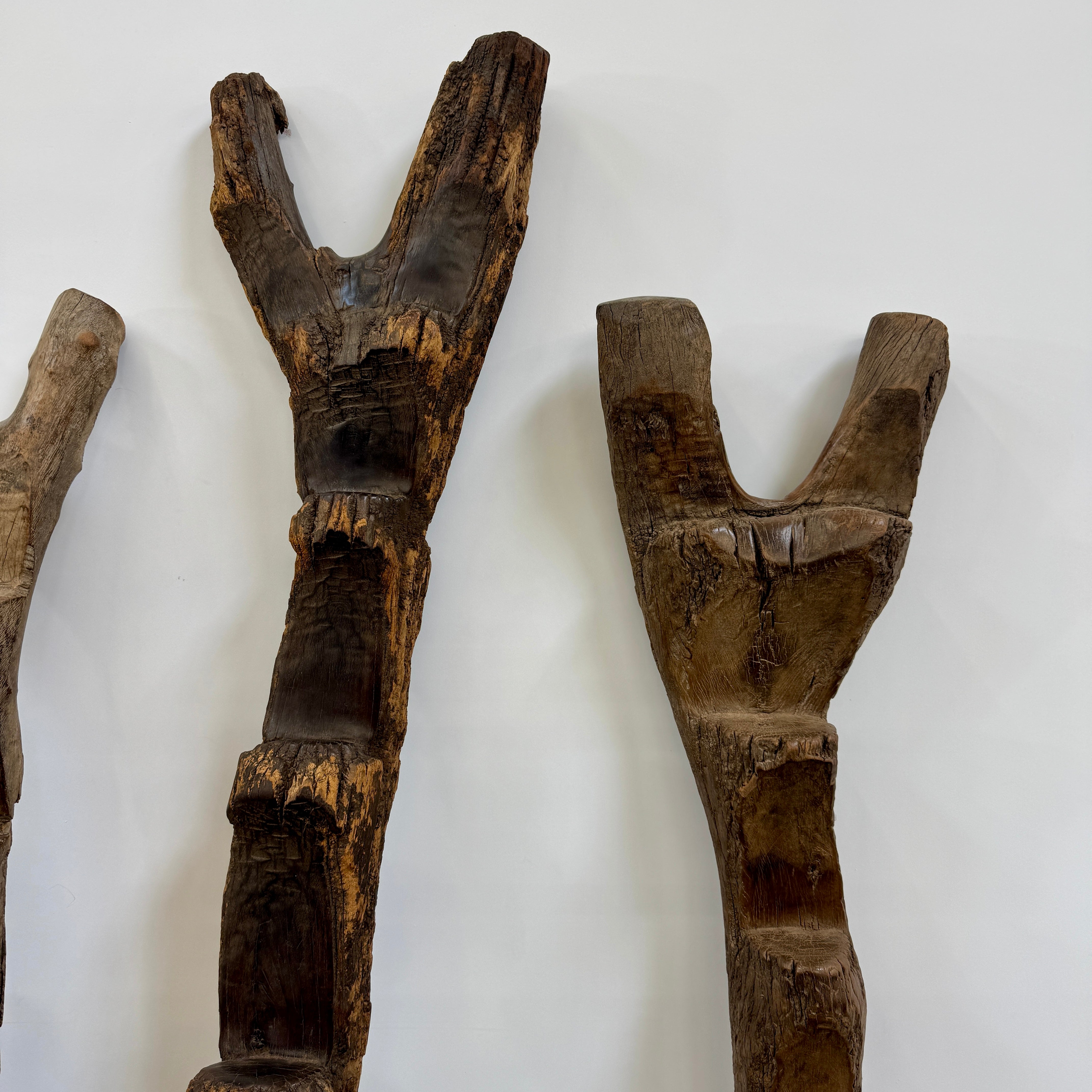 Four Vintage African Dogan Ladders, sold separately, feature wooden sticks with forked tops arranged vertically against a plain white background, showcasing distinctive African craftsmanship.