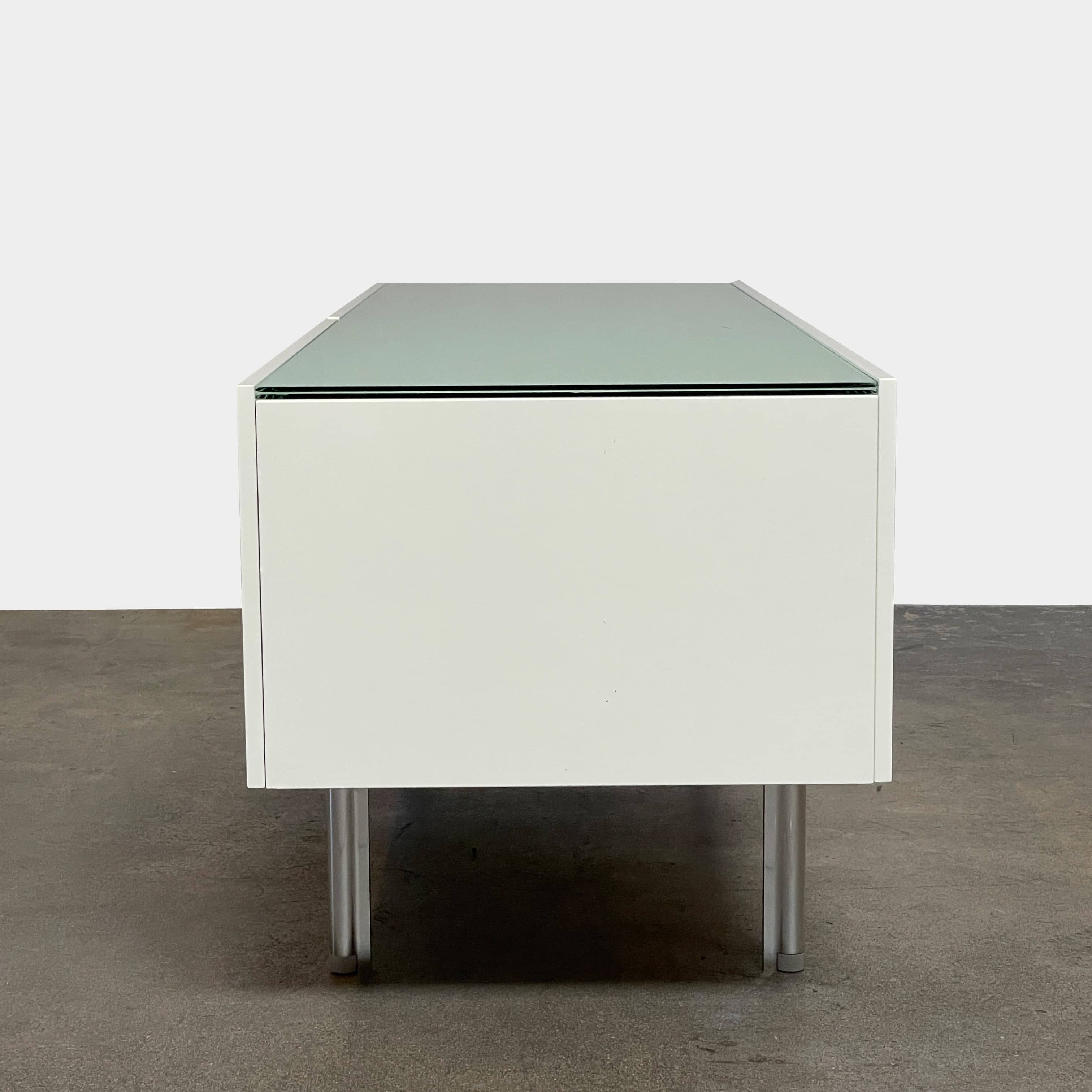 The Cassina 255-256 Flat Sideboard in glossy white lacquer features two left drawers, a spacious right compartment, and four metal legs, all by Cassina, shown against a plain background.