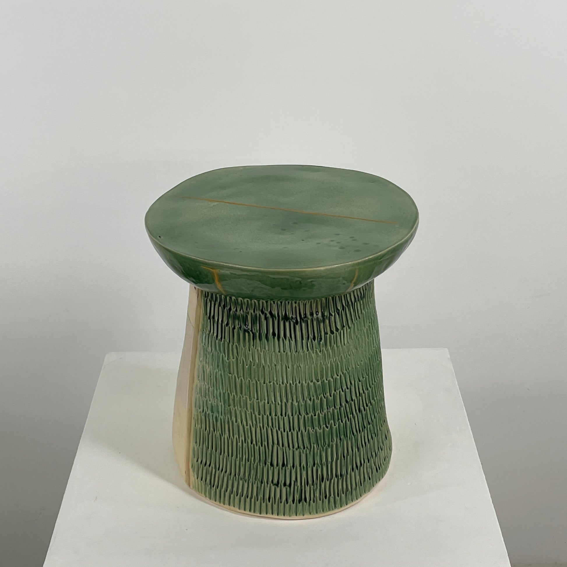 The Artist Allyn Davis Ceramic Side Table in Celadon features a textured cylindrical base and smooth round top, all on a plain white background.