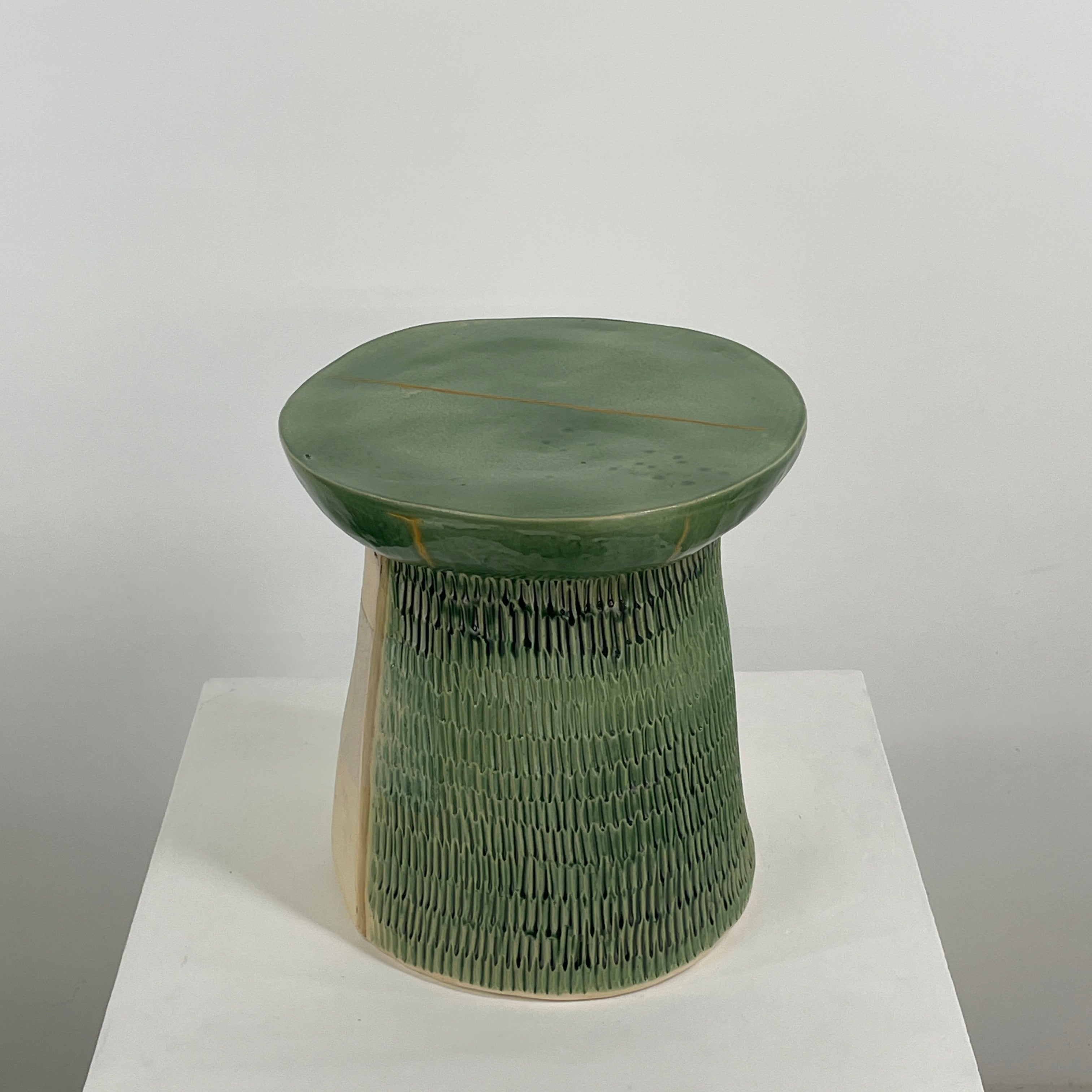 The Artist Allyn Davis Ceramic Side Table in Celadon features a textured cylindrical base and smooth round top, all on a plain white background.