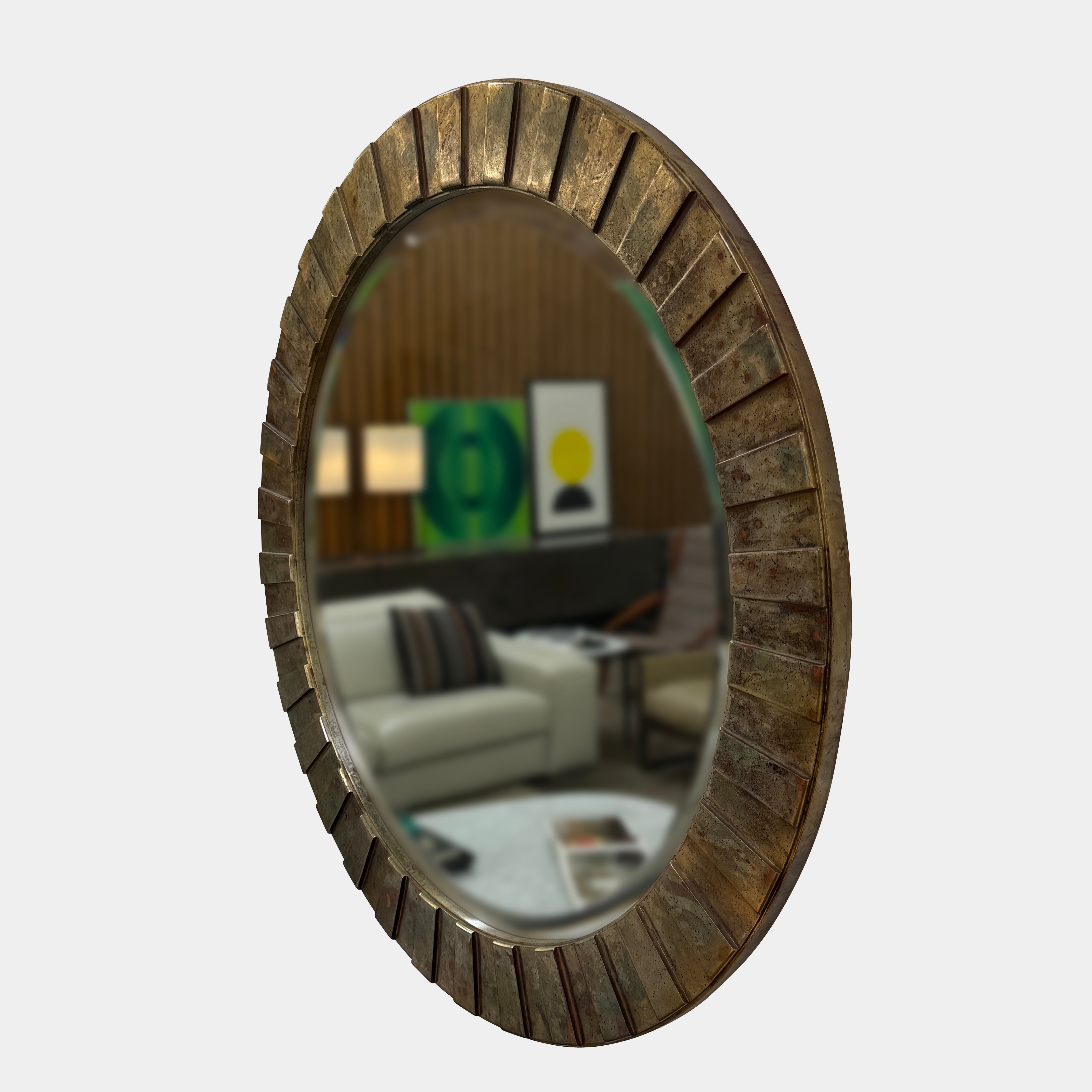 The Vintage Brutalist Mirror 1980s by Vintage features a textured bronze frame, reflecting a modern living room with sofas, wall art, lamps, and a coffee table—an elegant nod to iconic Brutalist design.