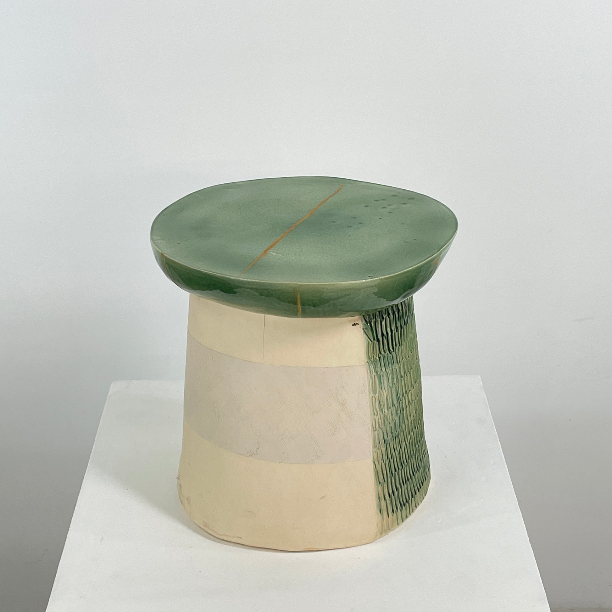 The Artist Allyn Davis Ceramic Side Table in Celadon features a textured cylindrical base and smooth round top, all on a plain white background.