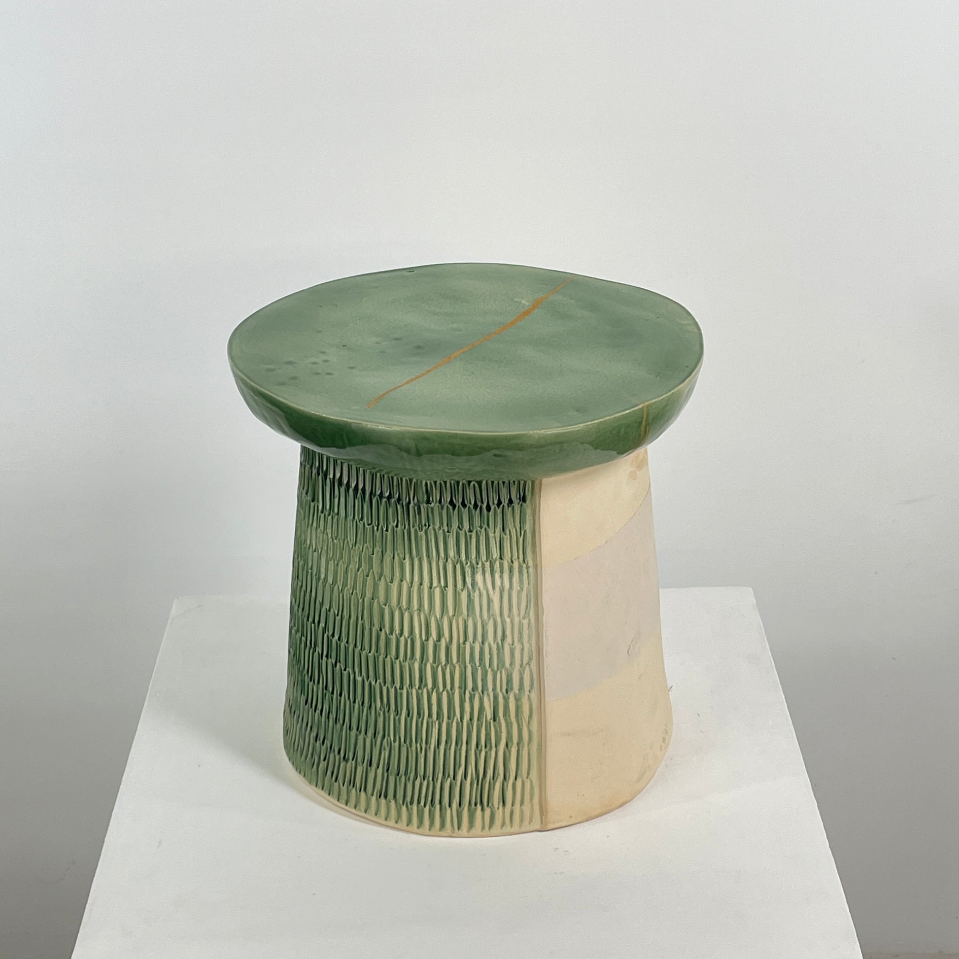 The Artist Allyn Davis Ceramic Side Table in Celadon features a textured cylindrical base and smooth round top, all on a plain white background.